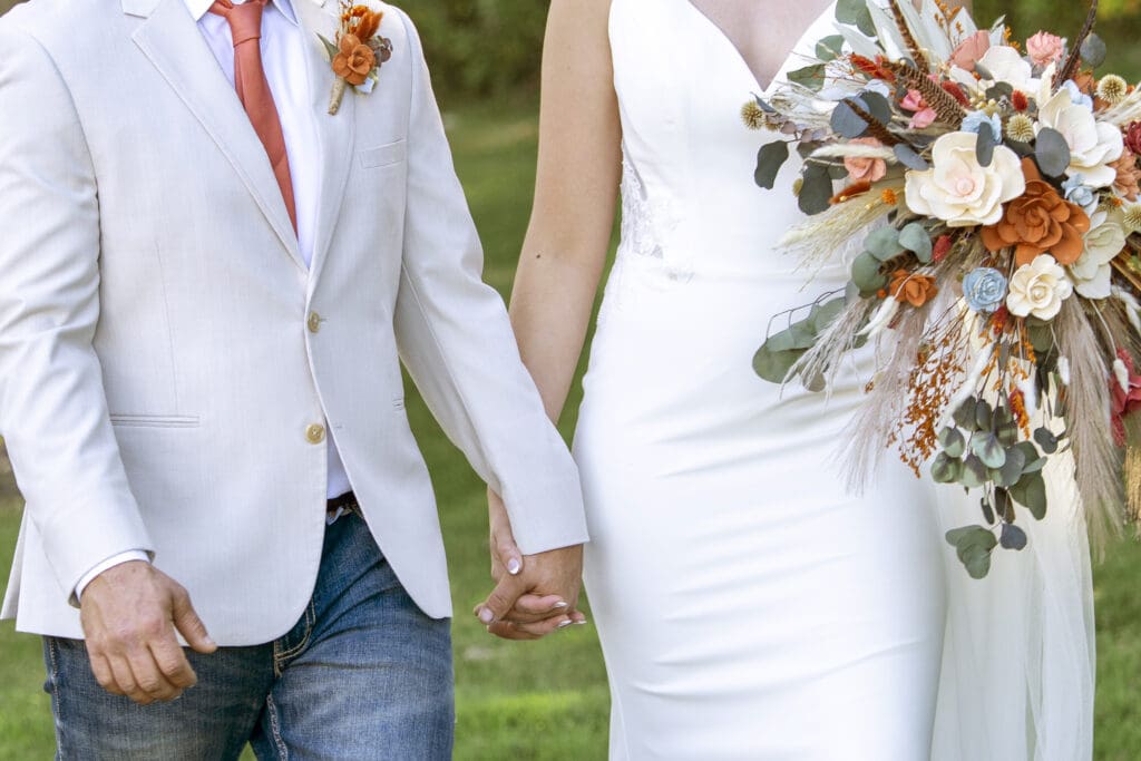 Groom and bride holding hands for their wedding photos.