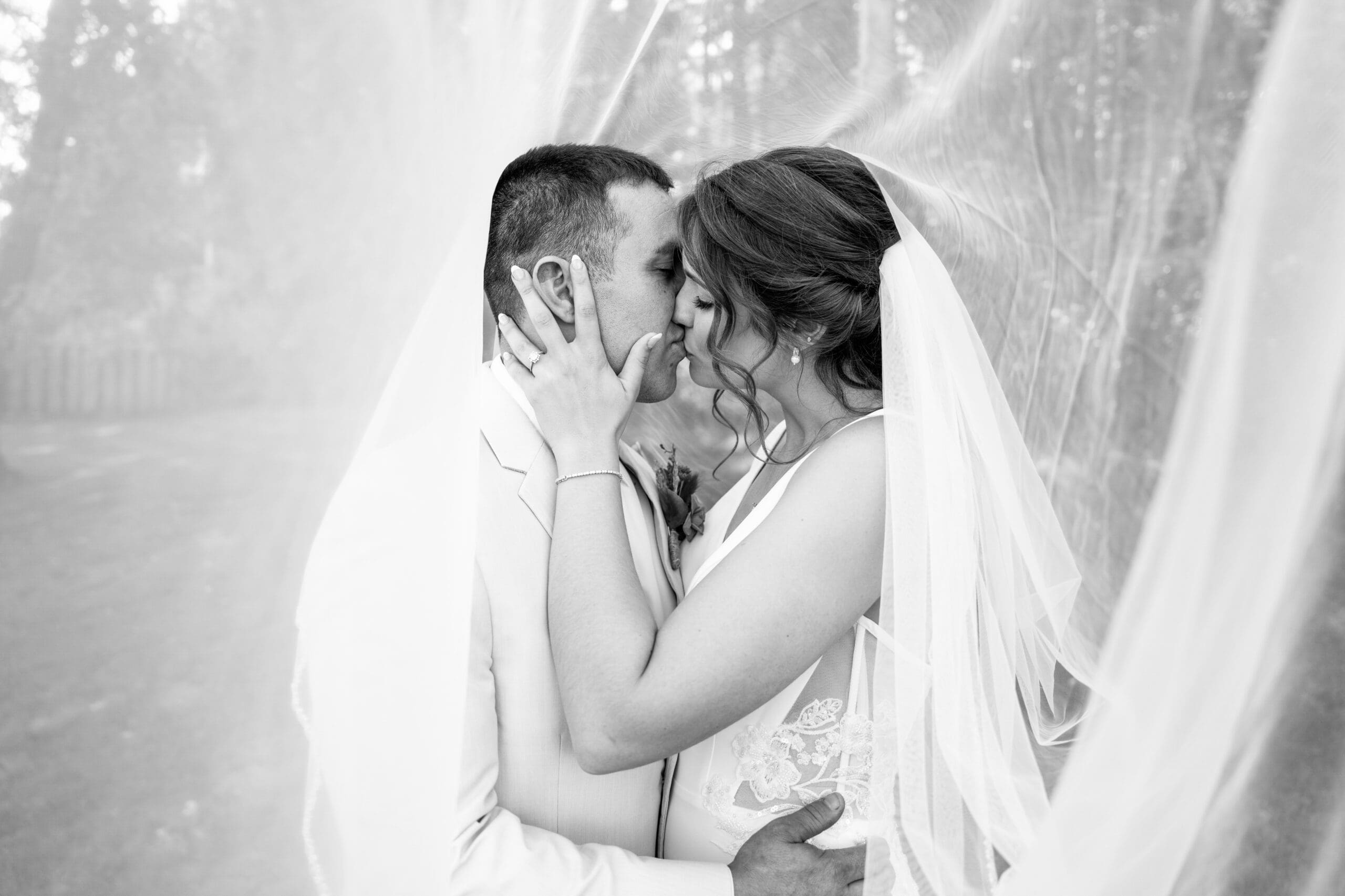 Creative veil portrait with the bride and groom kissing.