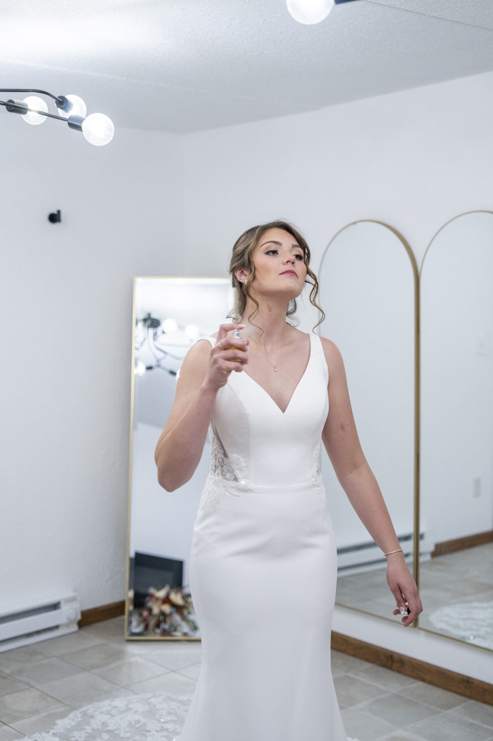 Bride spraying with perfume before her Wisconsin wedding ceremony.