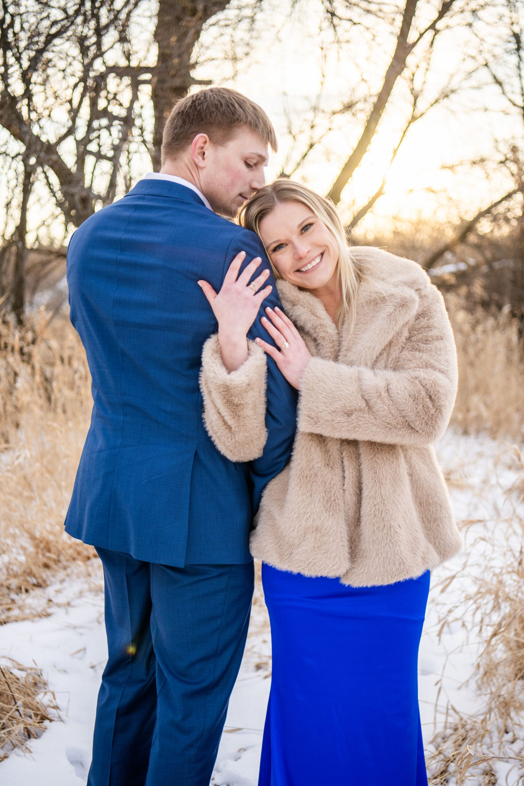 Close-up of couple with scenic Wisconsin wintery landscape in background.