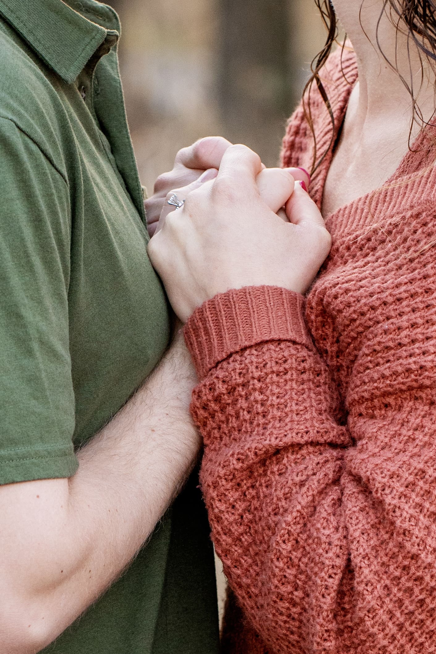 Engagement photos in Hartland, Wisconsin featuring a couple wearing layered outfits with neutral tones during an outdoor session.
