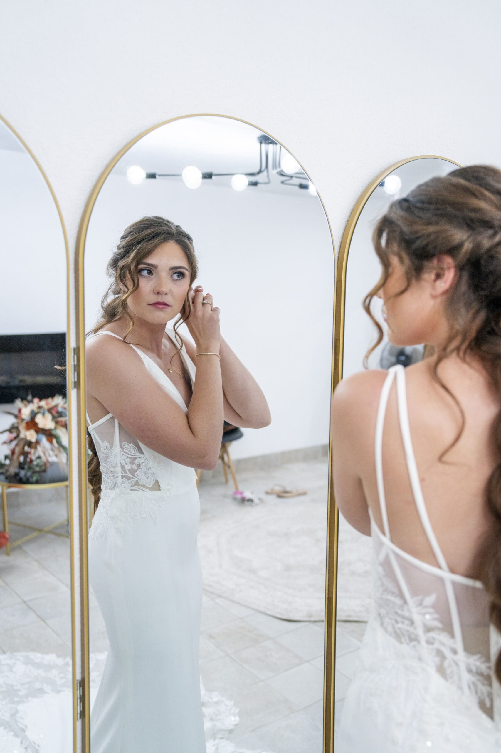 Bride putting on her earrings before her wedding ceremony.