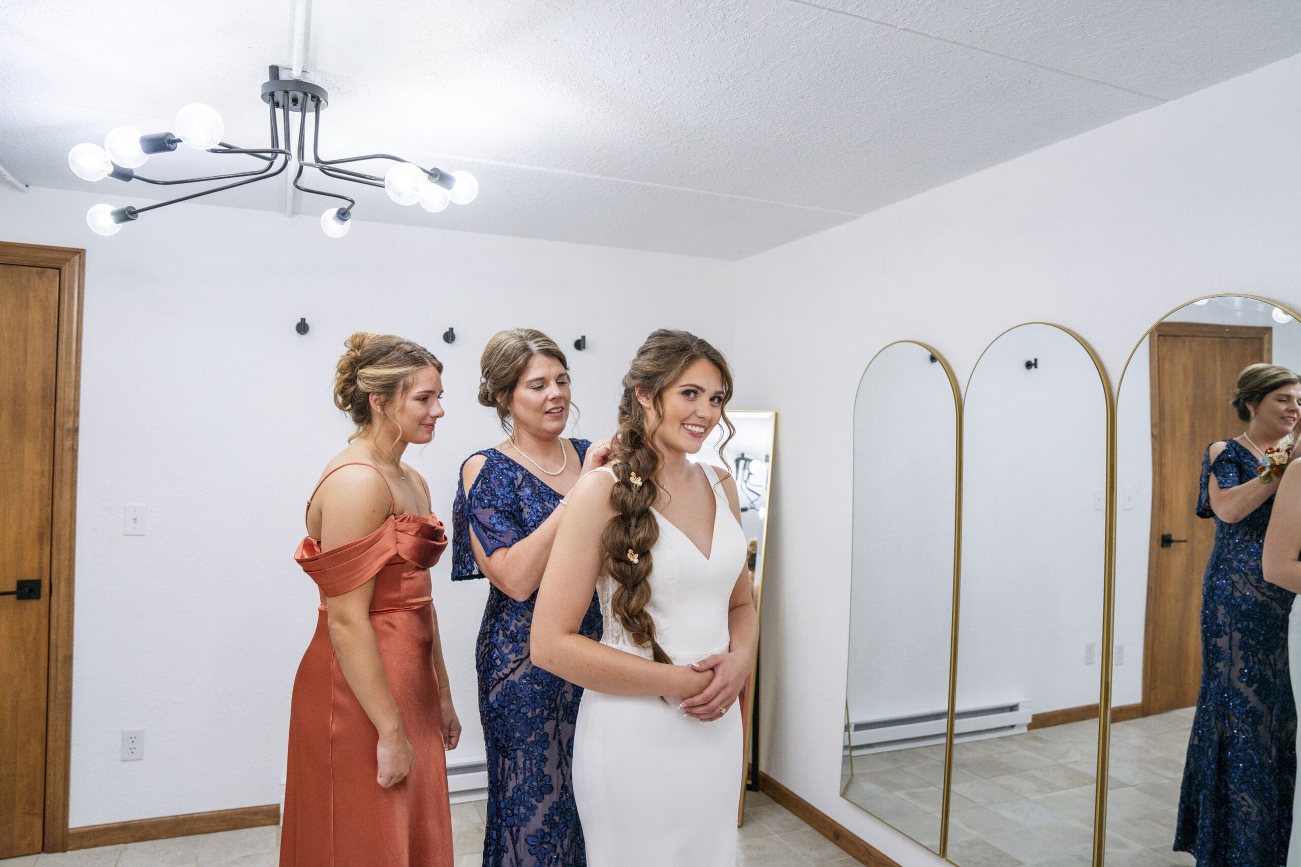 Bride's mother clipping on the bride's necklace.
