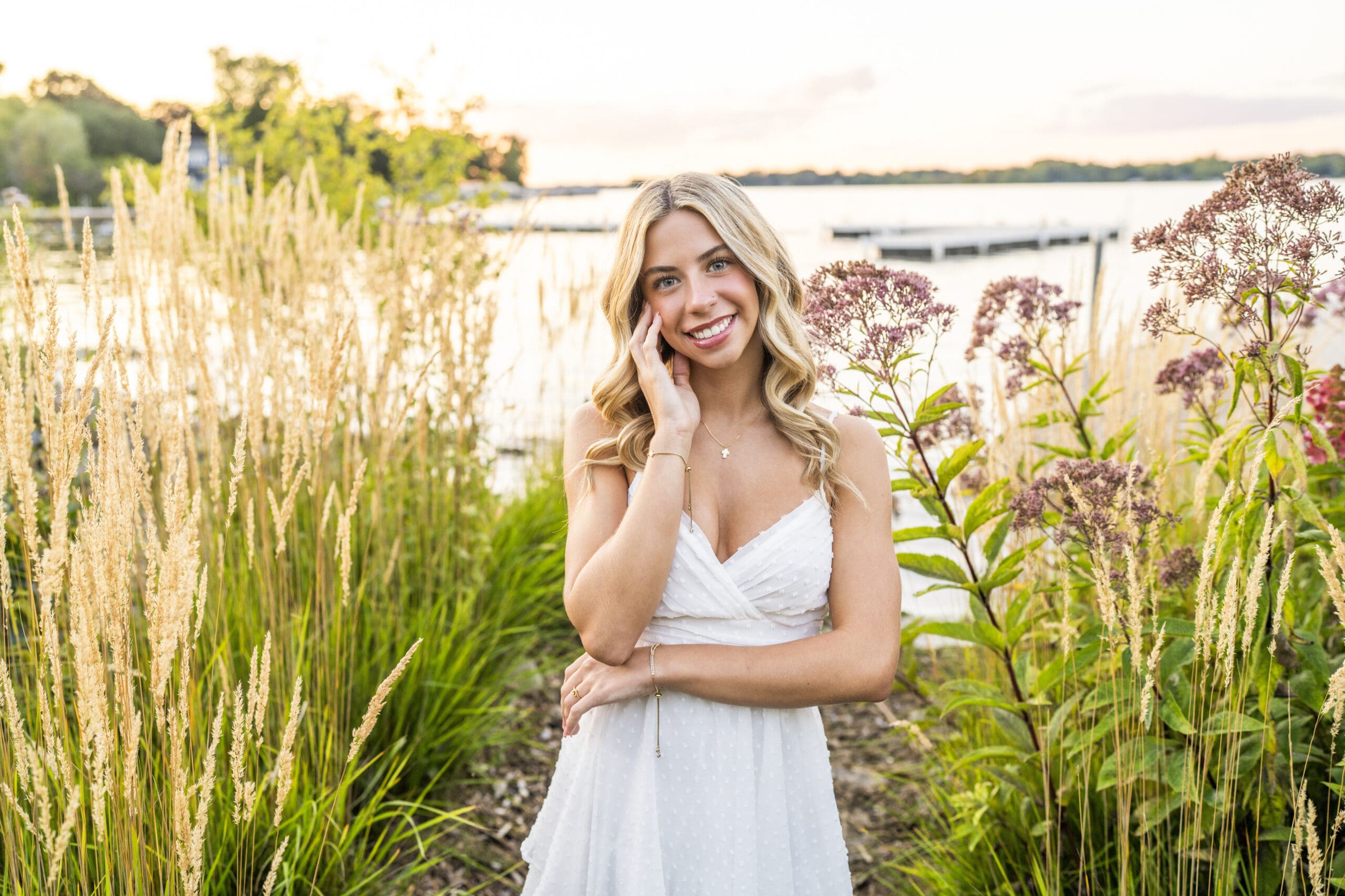 Arrowhead high school senior girl standing in front of Lac La Belle, one of the popular senior portrait locations in Wisconsin.
