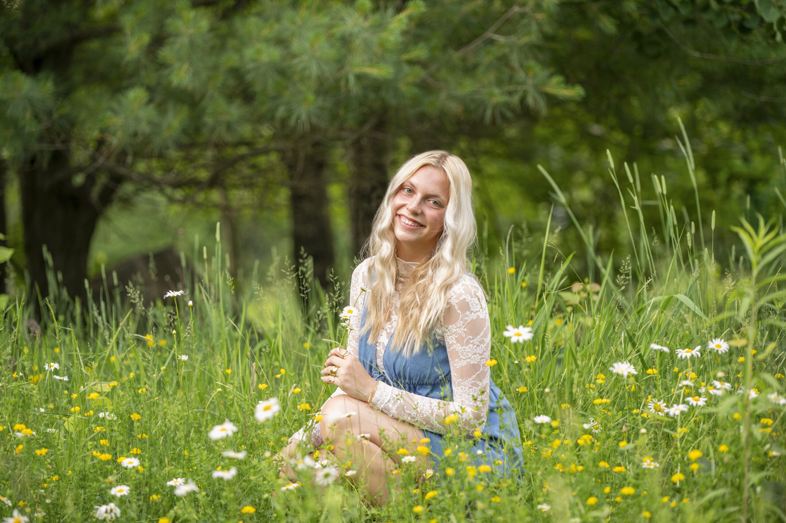 Arrowhead high school senior kneeling in a flower field.