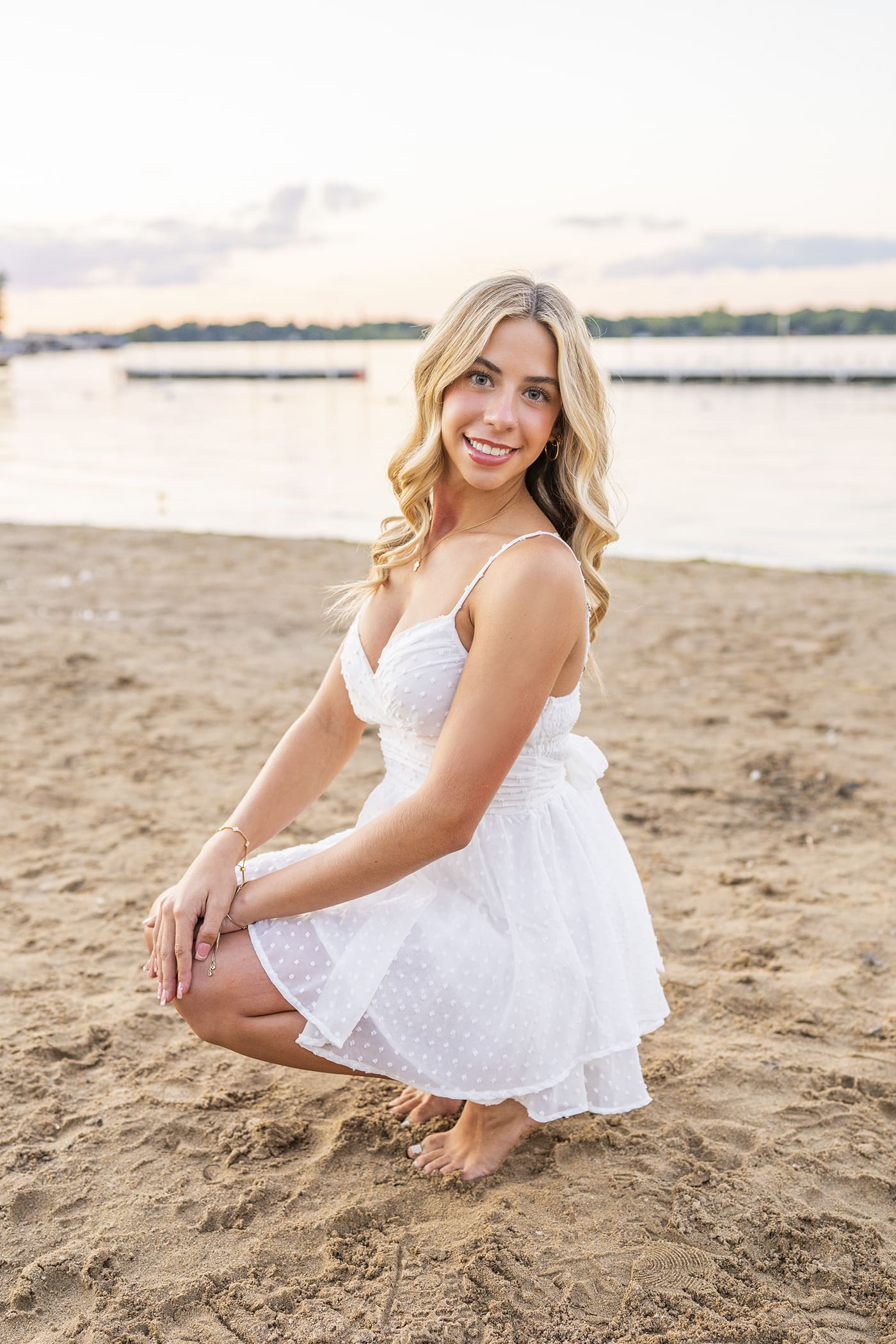 Arrowhead high school senior girl sitting on the beach at sunset, showing senior girl photo tips for relaxed, natural portraits