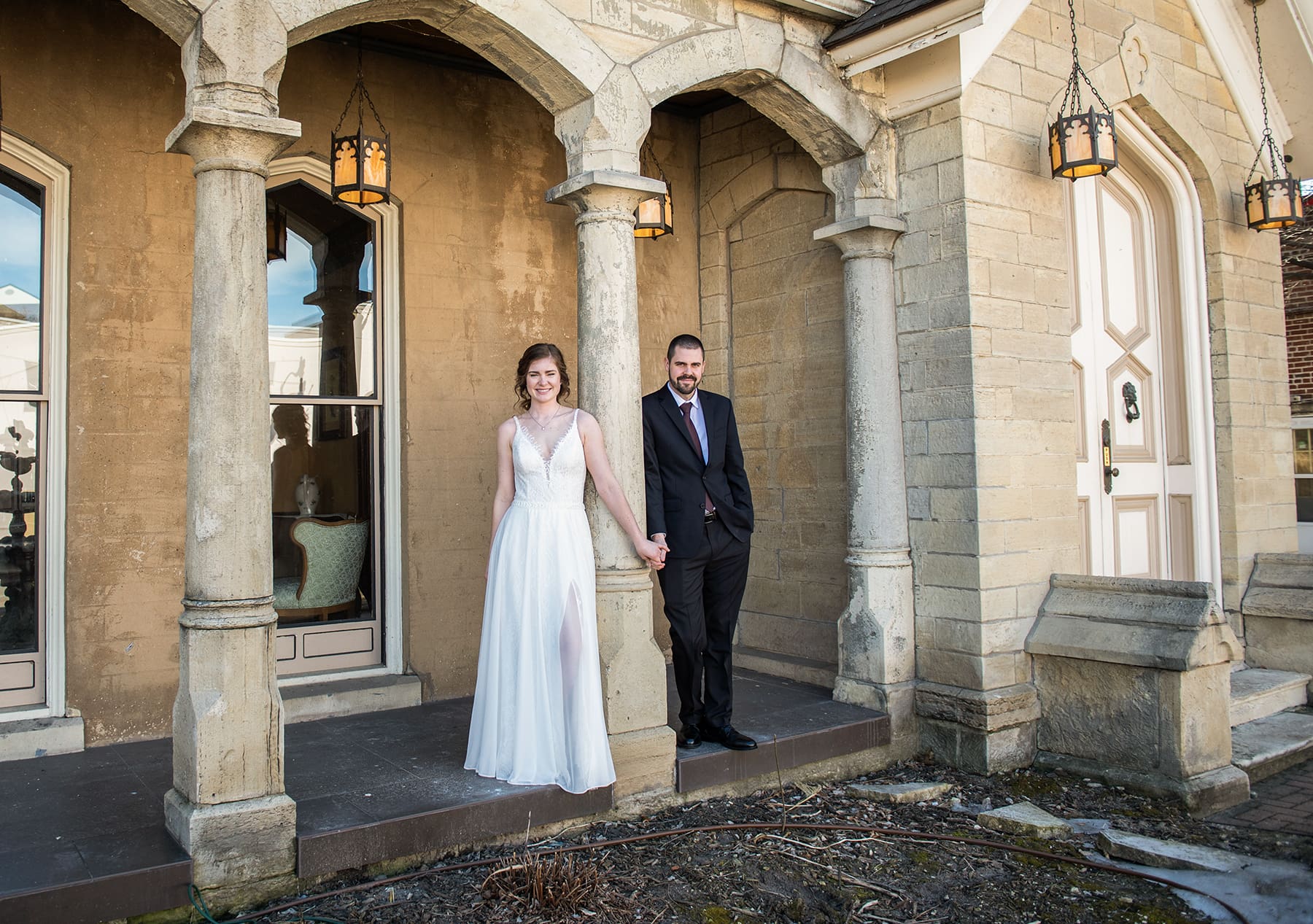 Southeast WI groom and bride holding hands by a gorgeous old building in Milwaukee