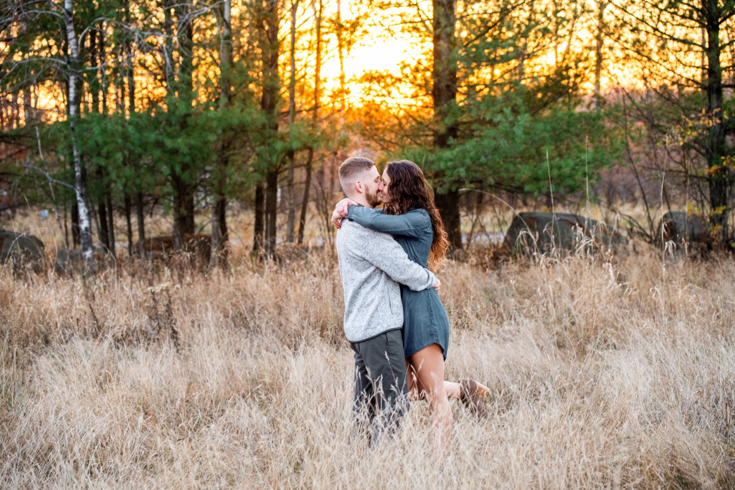 Couple kissing in a Wisconsin field during one of their engagement sessions in Waukesha County