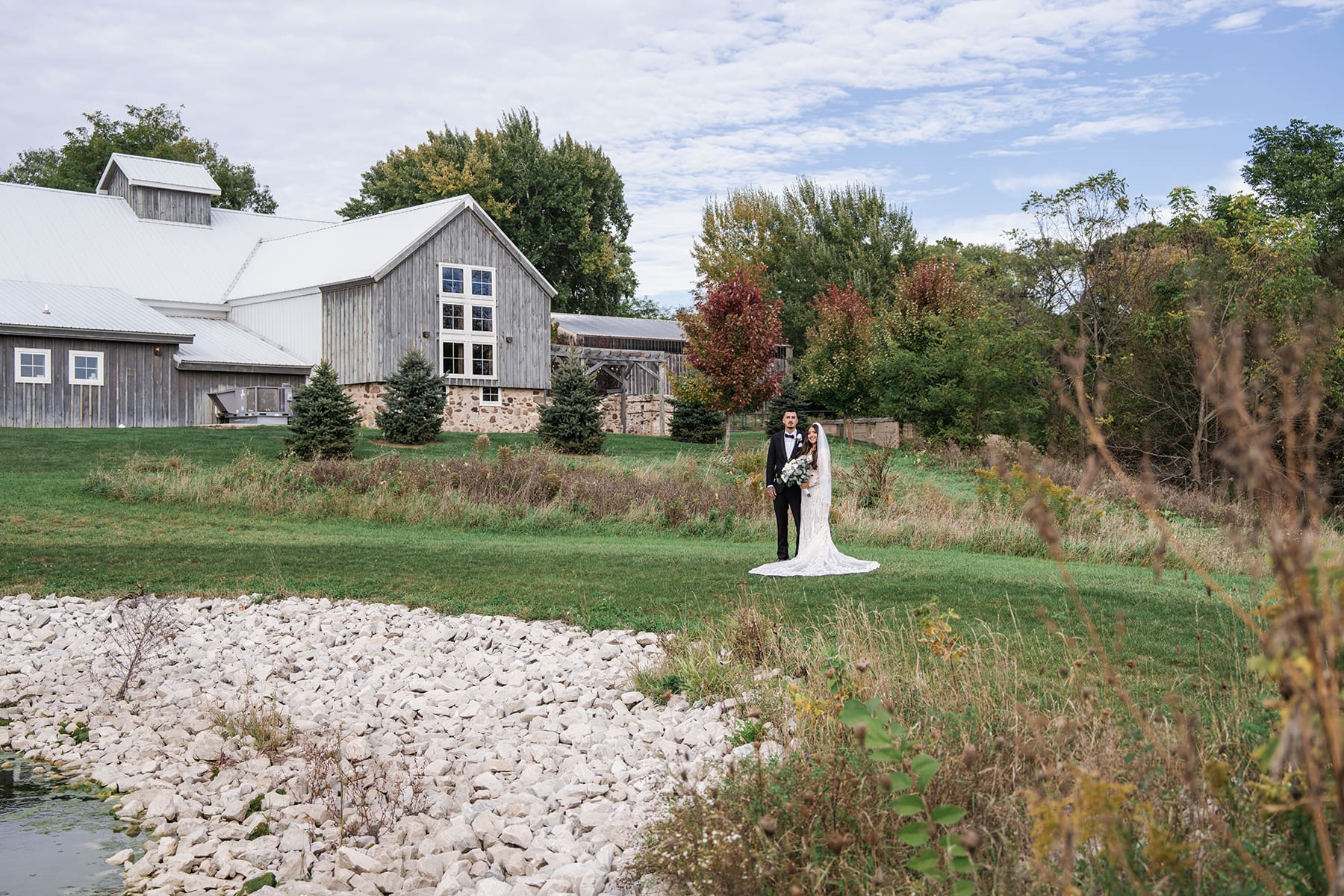 Couples portrait with Lilac Acres wedding venue behind them
