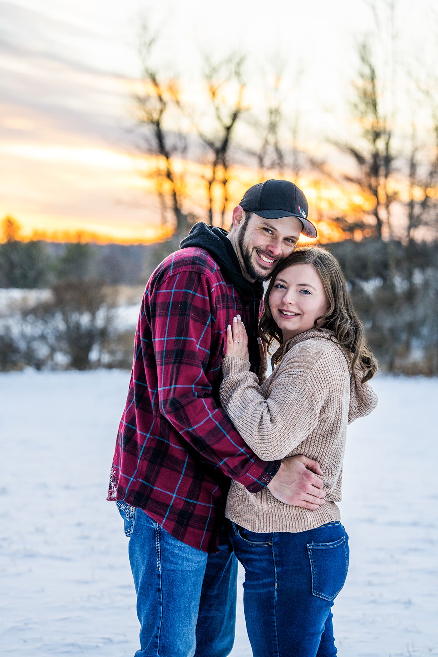 Engaged couple smiling in the snow in Oconomowoc