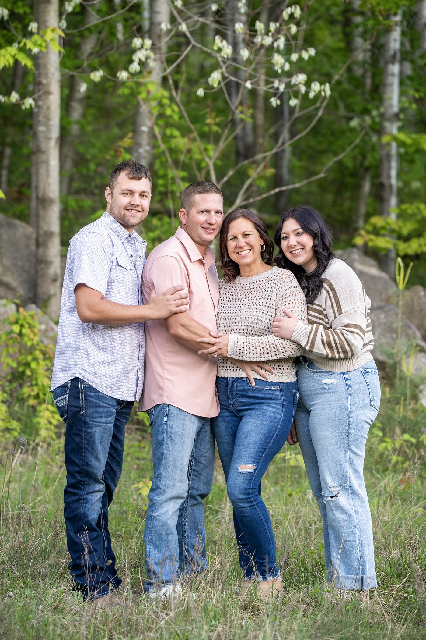 Family smiling at camera for their family portrait session in Waukesha. 