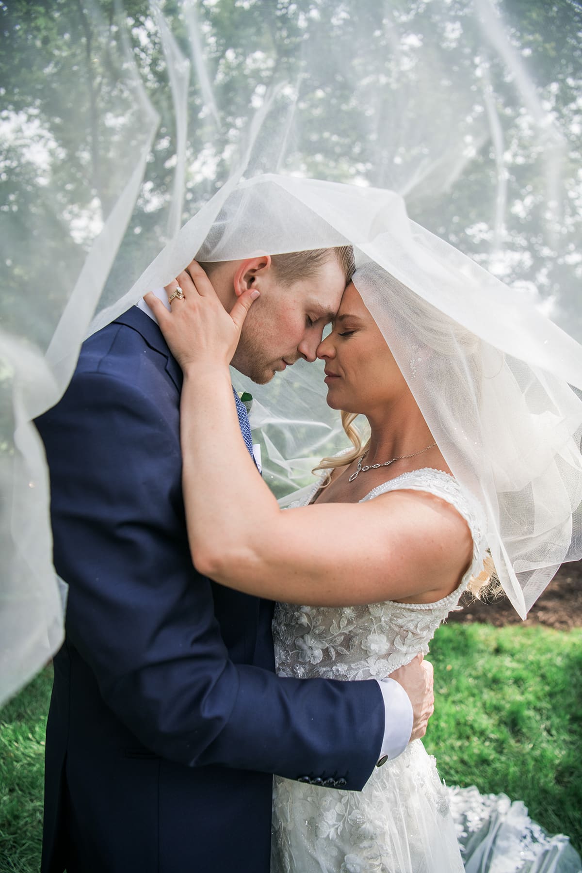 Newly weds sharing an intimate moment under the wedding veil