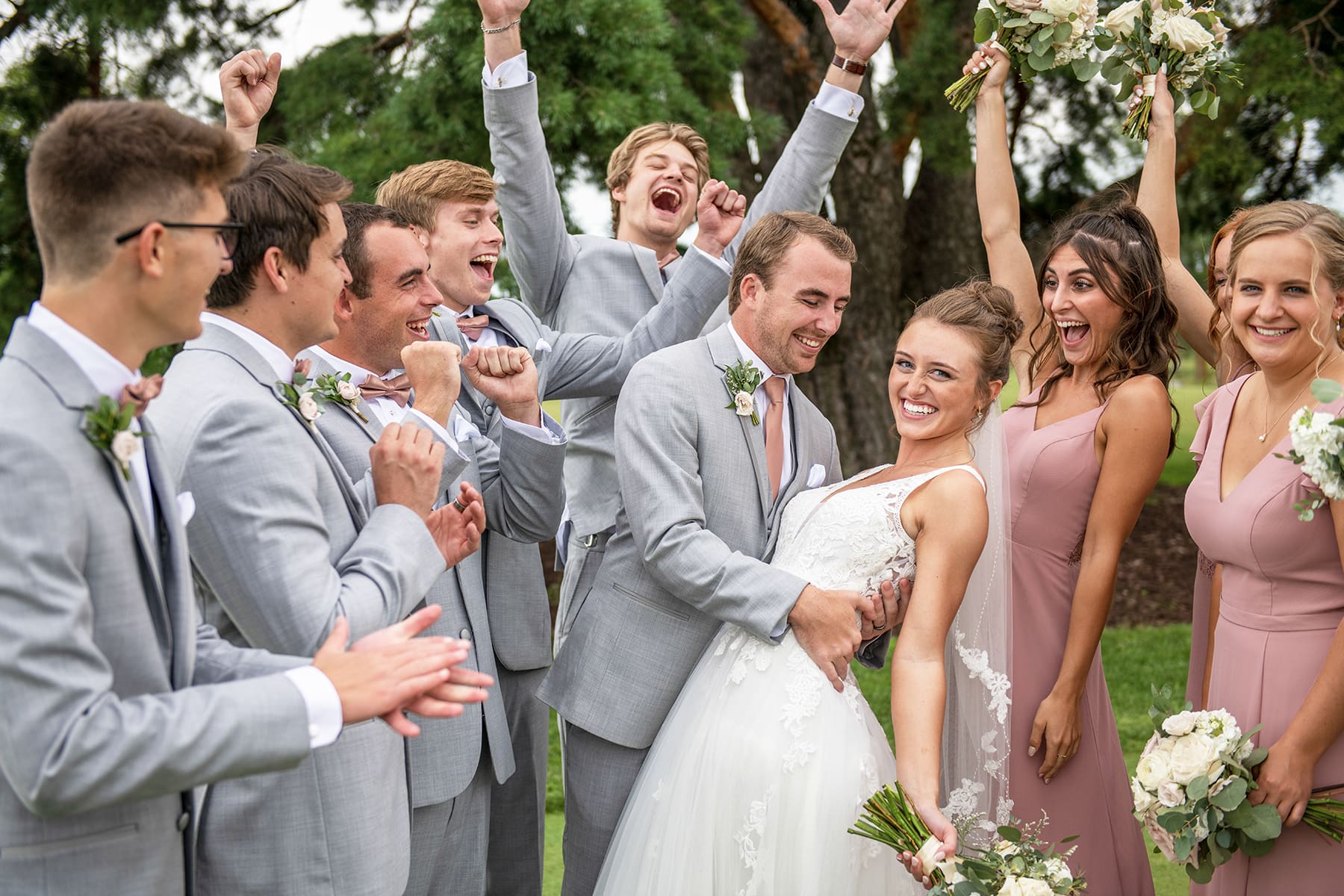 Oconomowoc groom dipping bride with wedding party cheering 