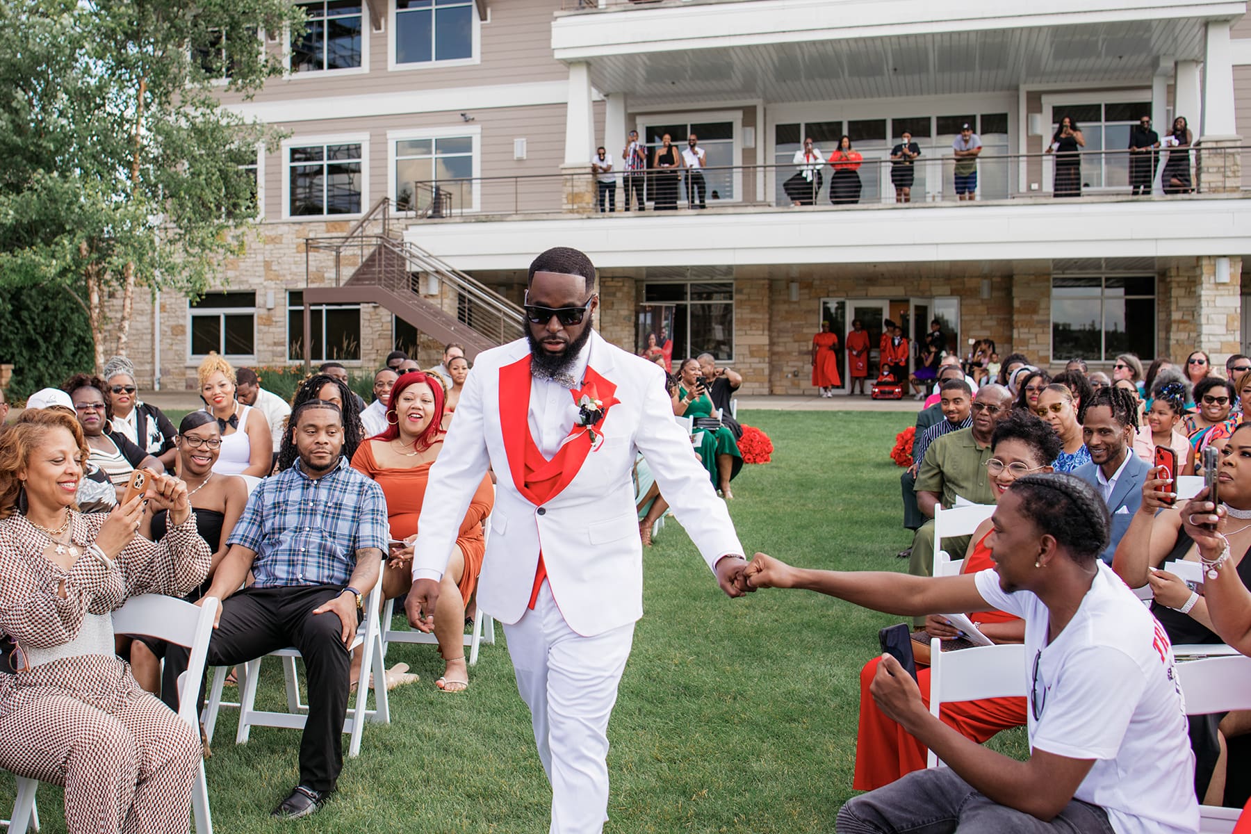 Oconomowoc groom fist bumping while walking down the aisle