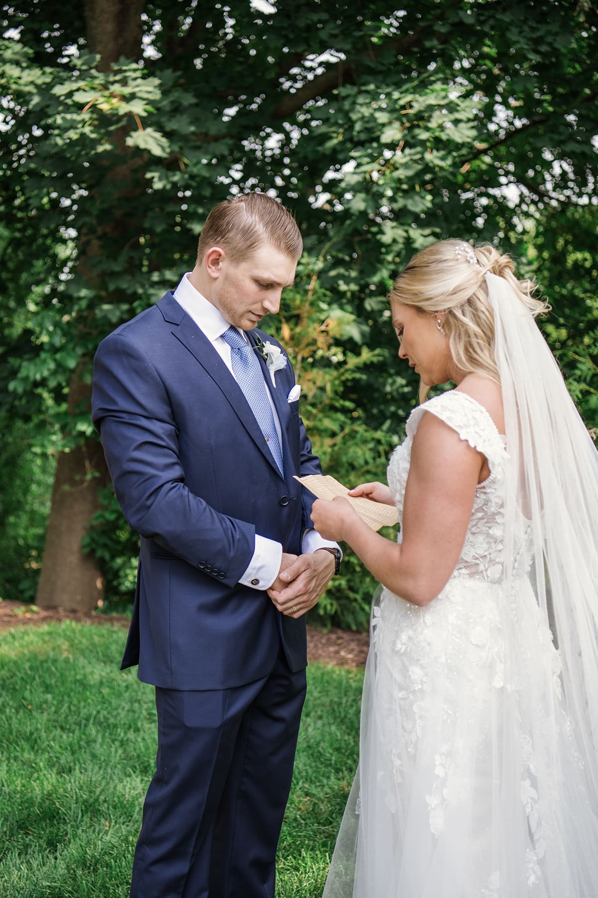 Groom listening as bride reads wedding vows 