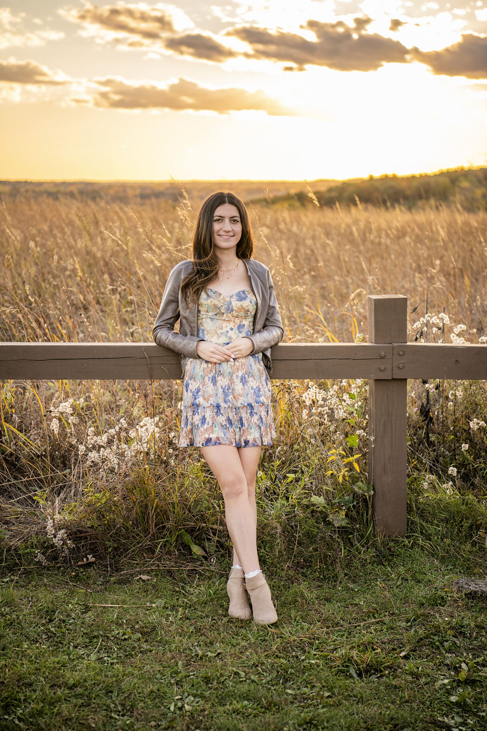 Hartford senior leaning against wooden fence in the fall.