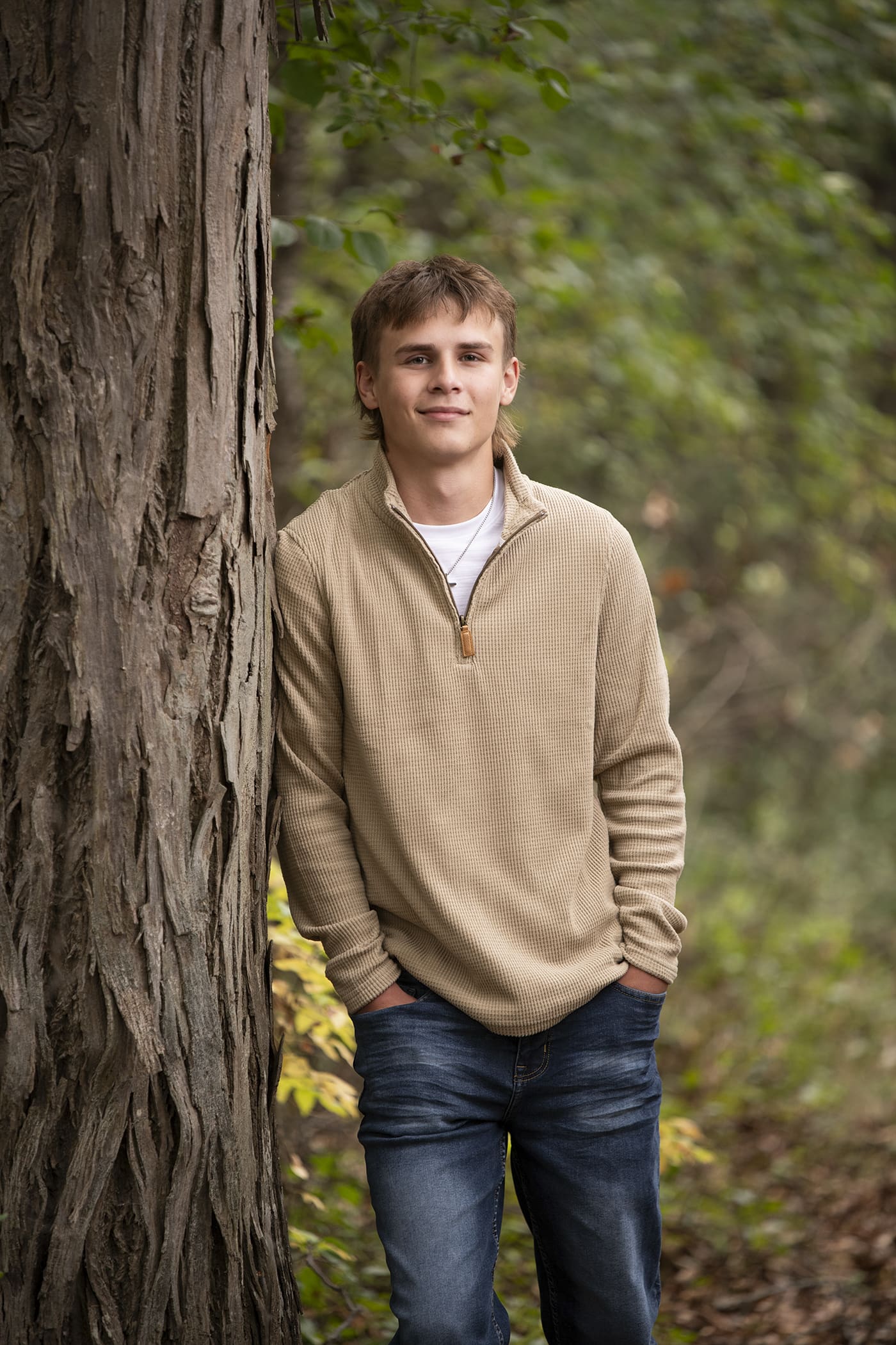 Hartland senior guy leaning on tree-tips for your photo session.