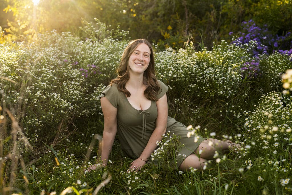 Hartford senior sitting in flower field. 