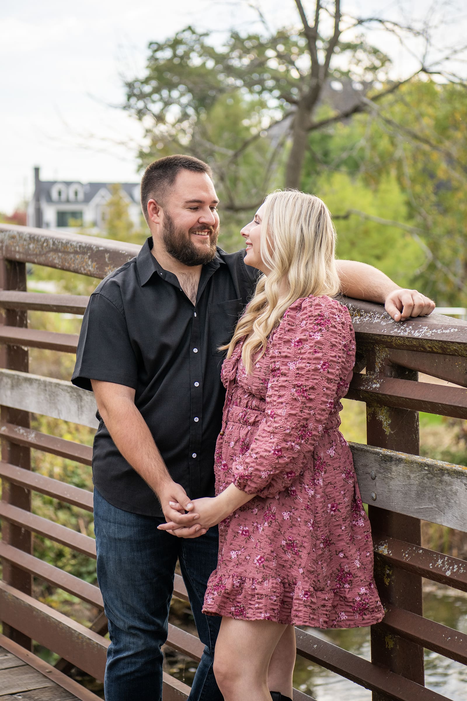 Hartland couple standing on bridge looking at each other 