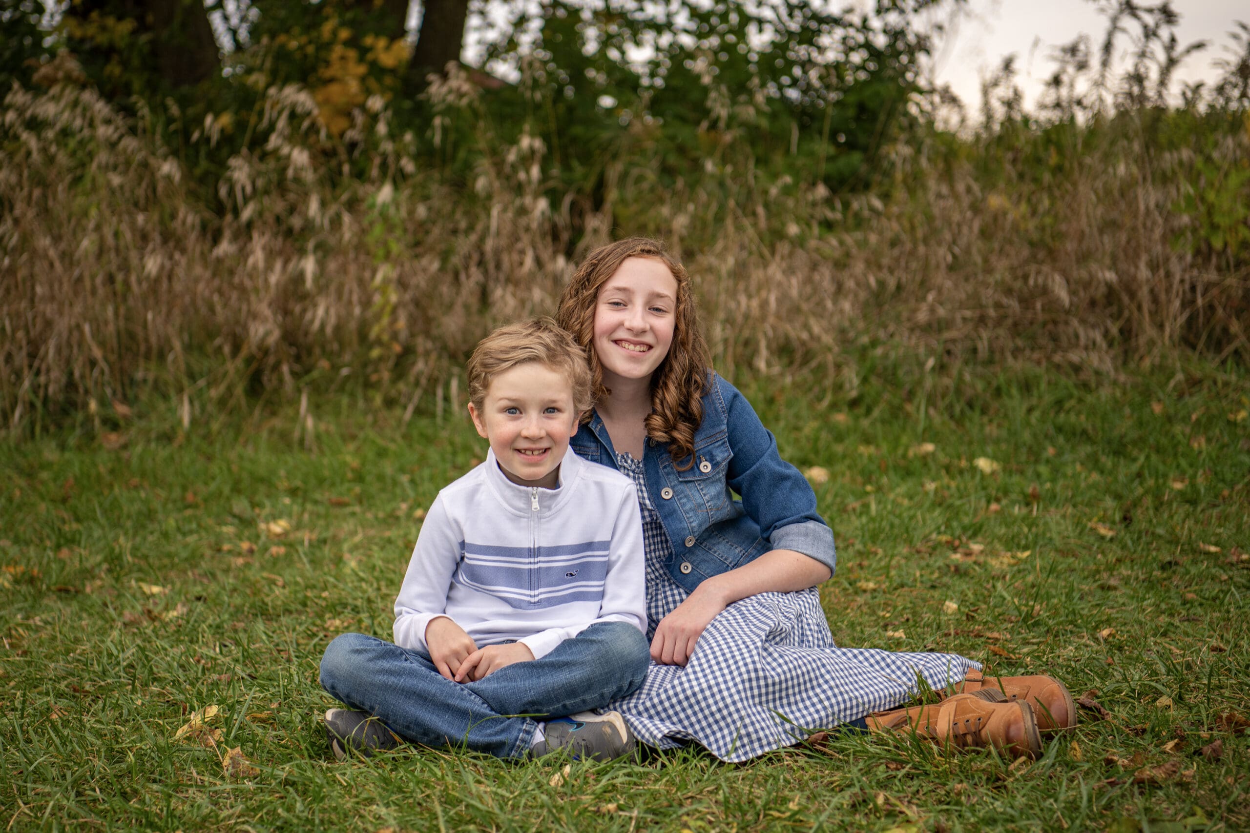 Hartland family sitting on ground smiling for the camera