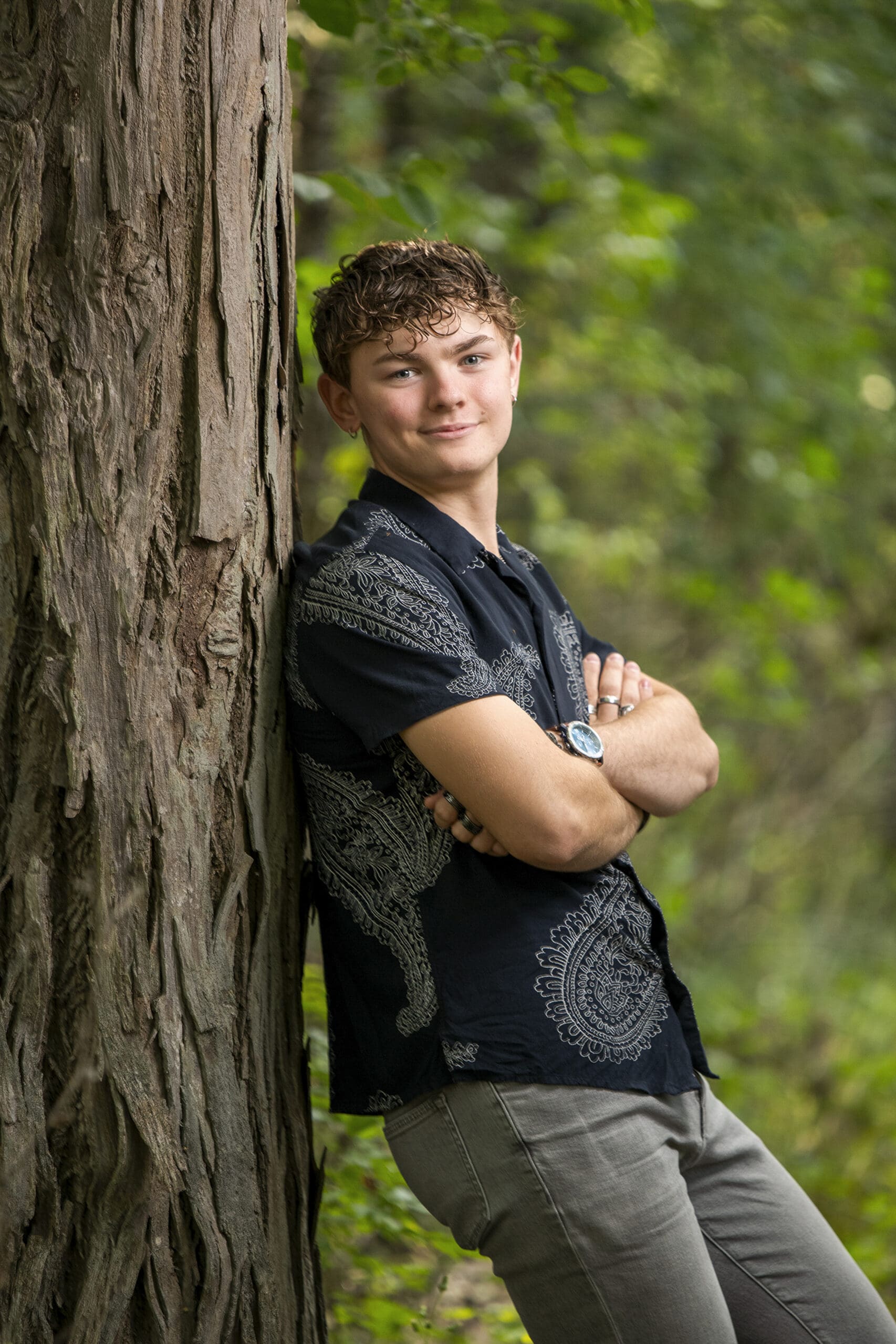Hartland senior leaning against tree in Merton. 