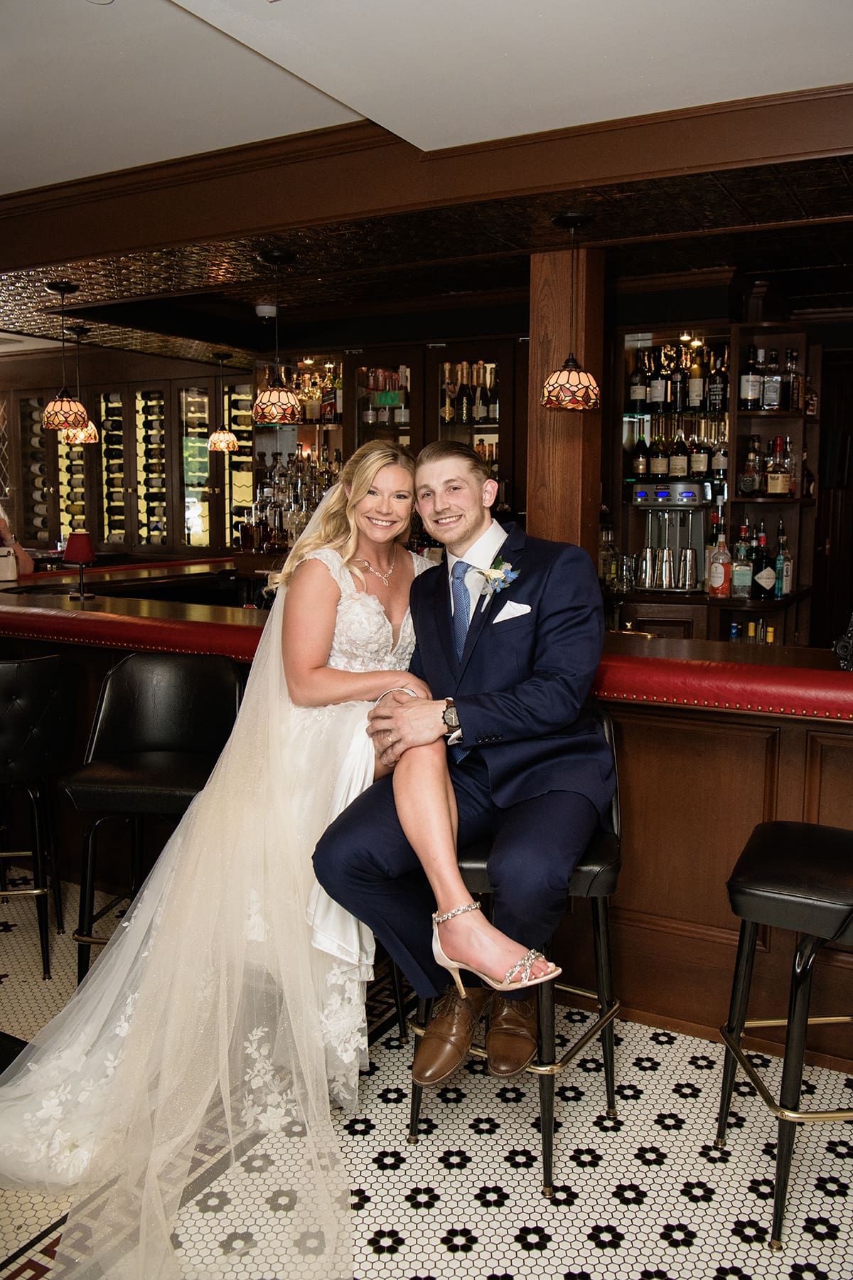 Couples portrait of the bride and groom smiling at the camera inside the Red Circle Inn bar 