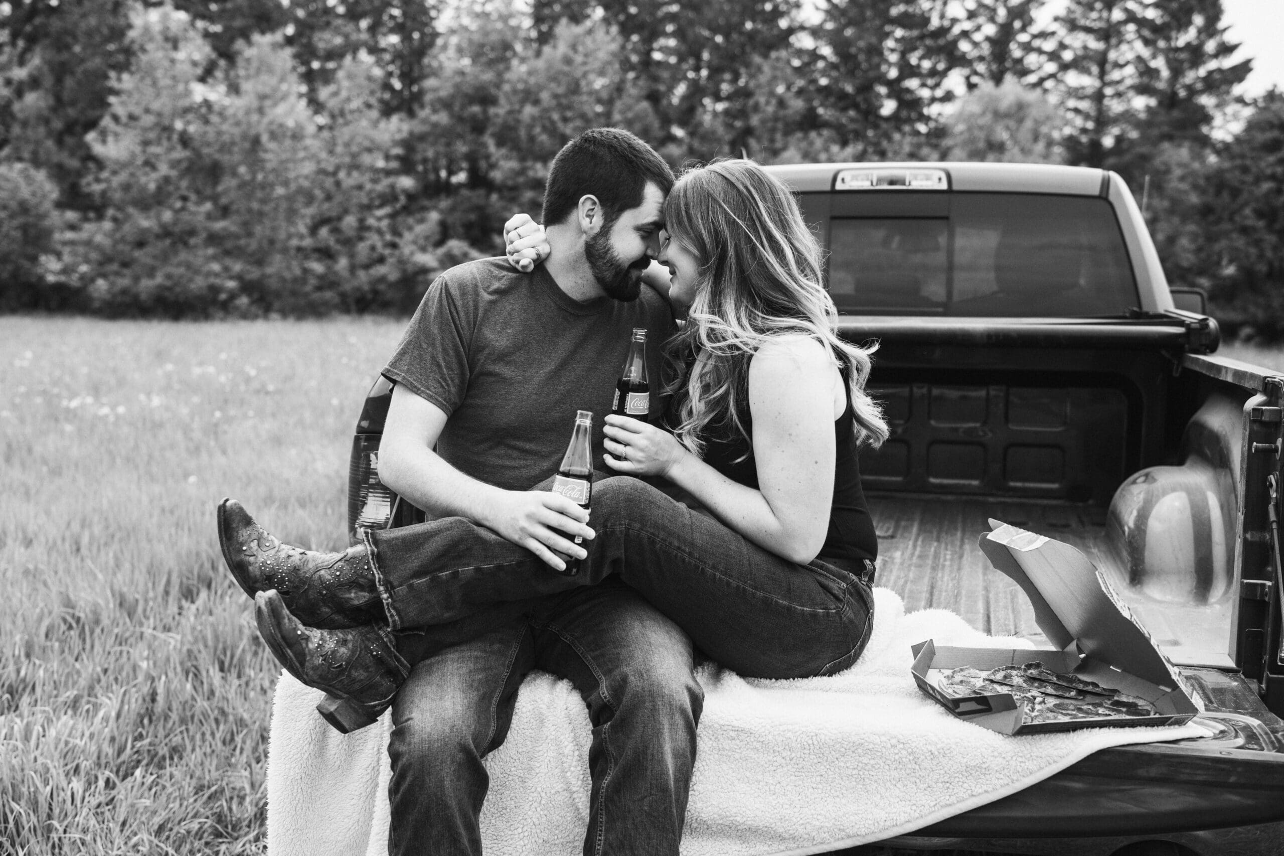 Couple sitting on a truck in Menomonee Falls using engagement session tips for Waukesha County to feel relaxed on camera