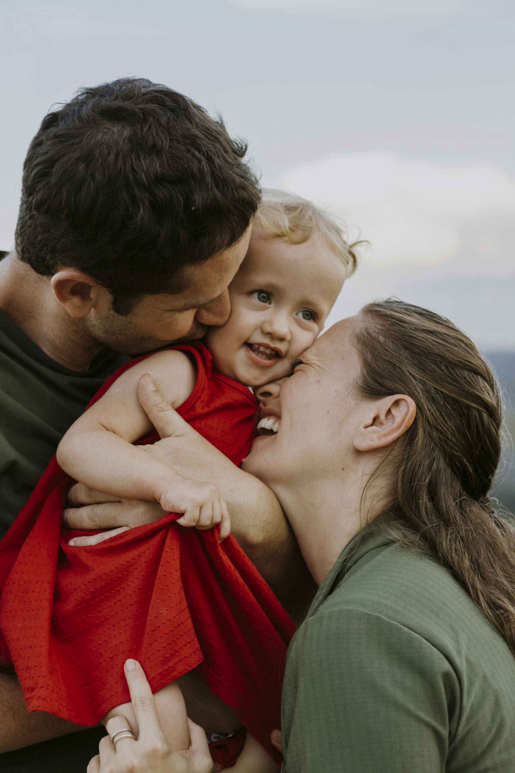 Mother and father hugging their child in Hartland, WI. 