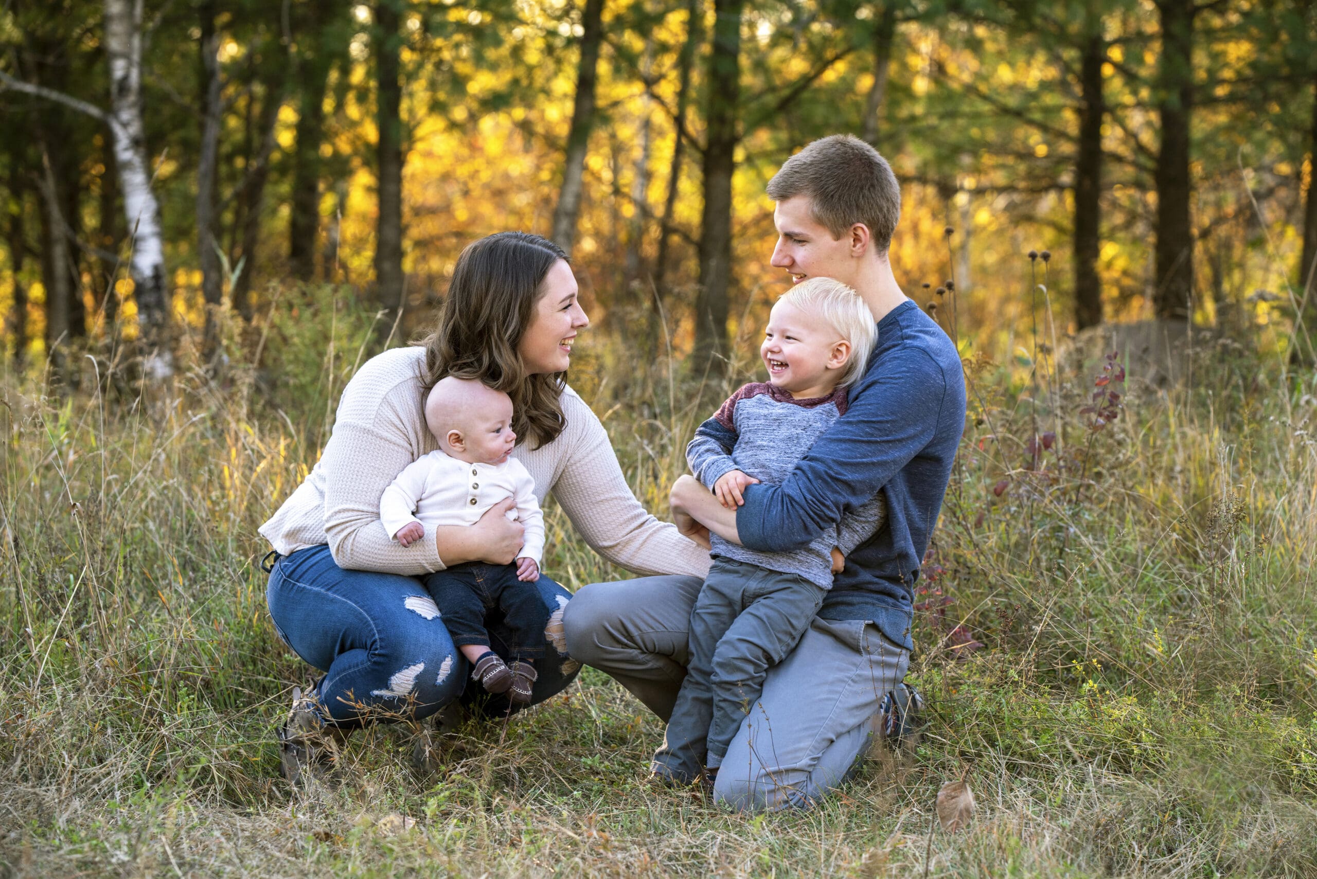 Oconomowoc family playing in a field while showcasing relaxed family photo outfit ideas.