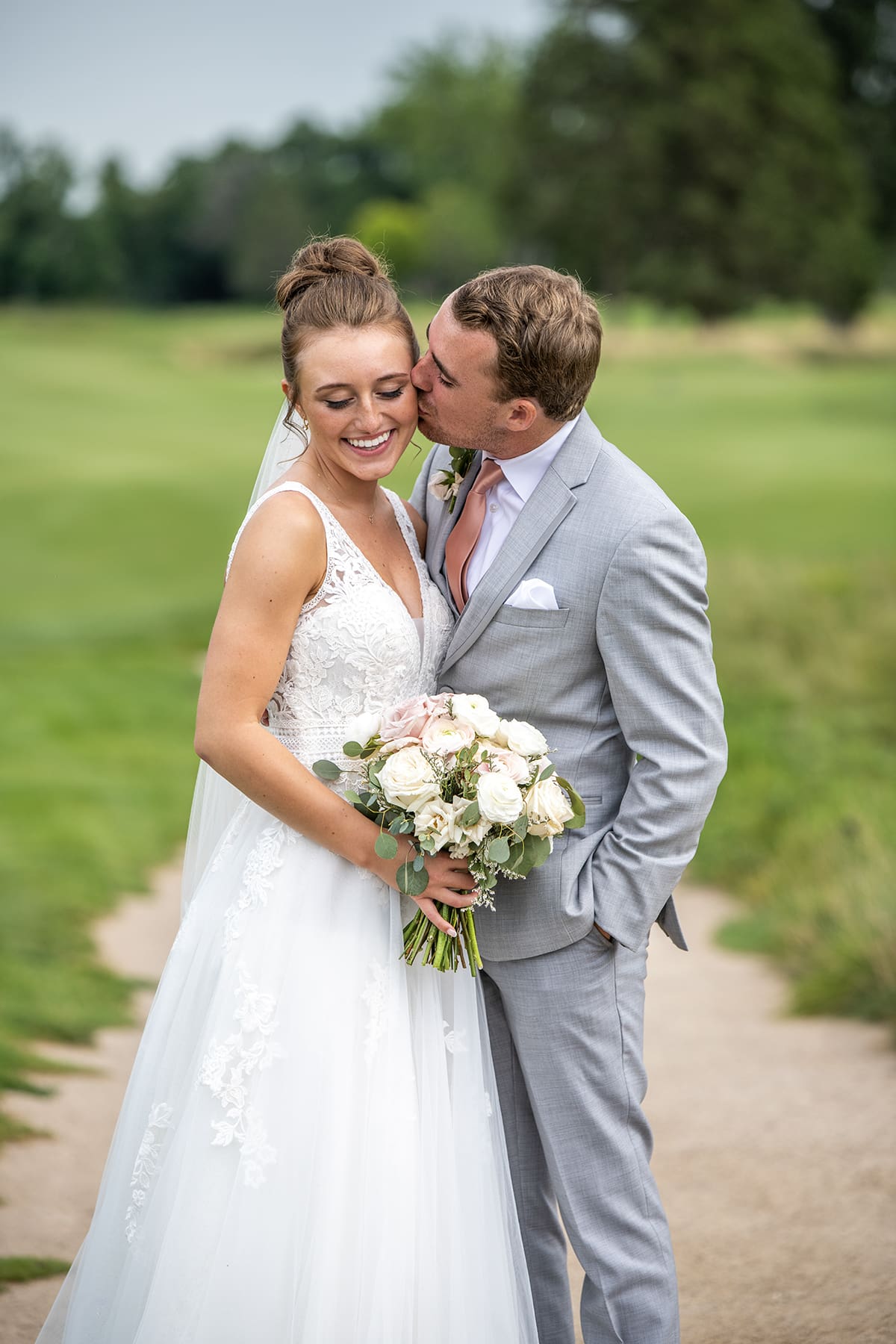 Groom kissing bride at Lac La Belle wedding venue