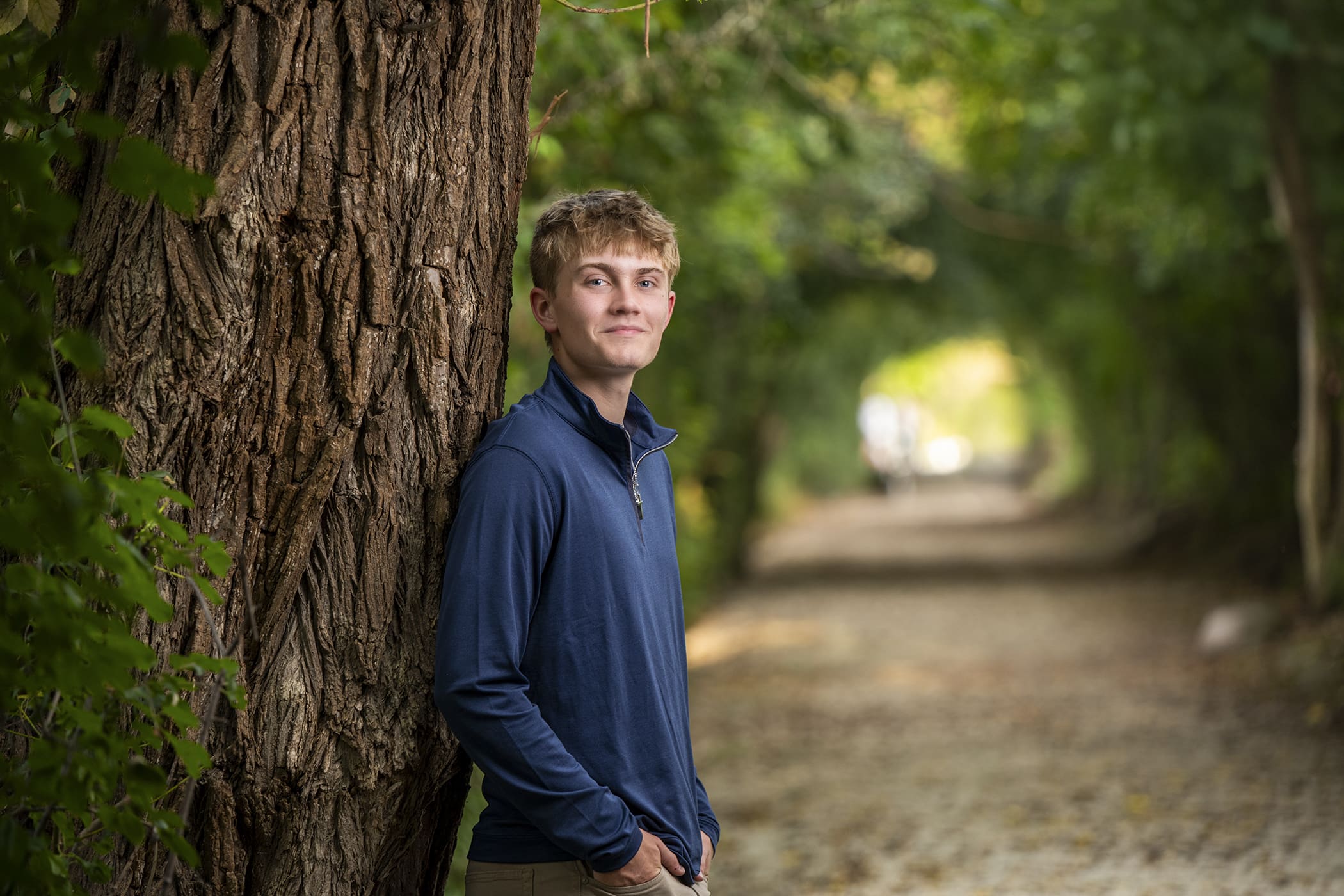 High school senior guy leaning on a tree in Oconomowoc, demonstrating relaxed senior guy photo tips for natural portraits.