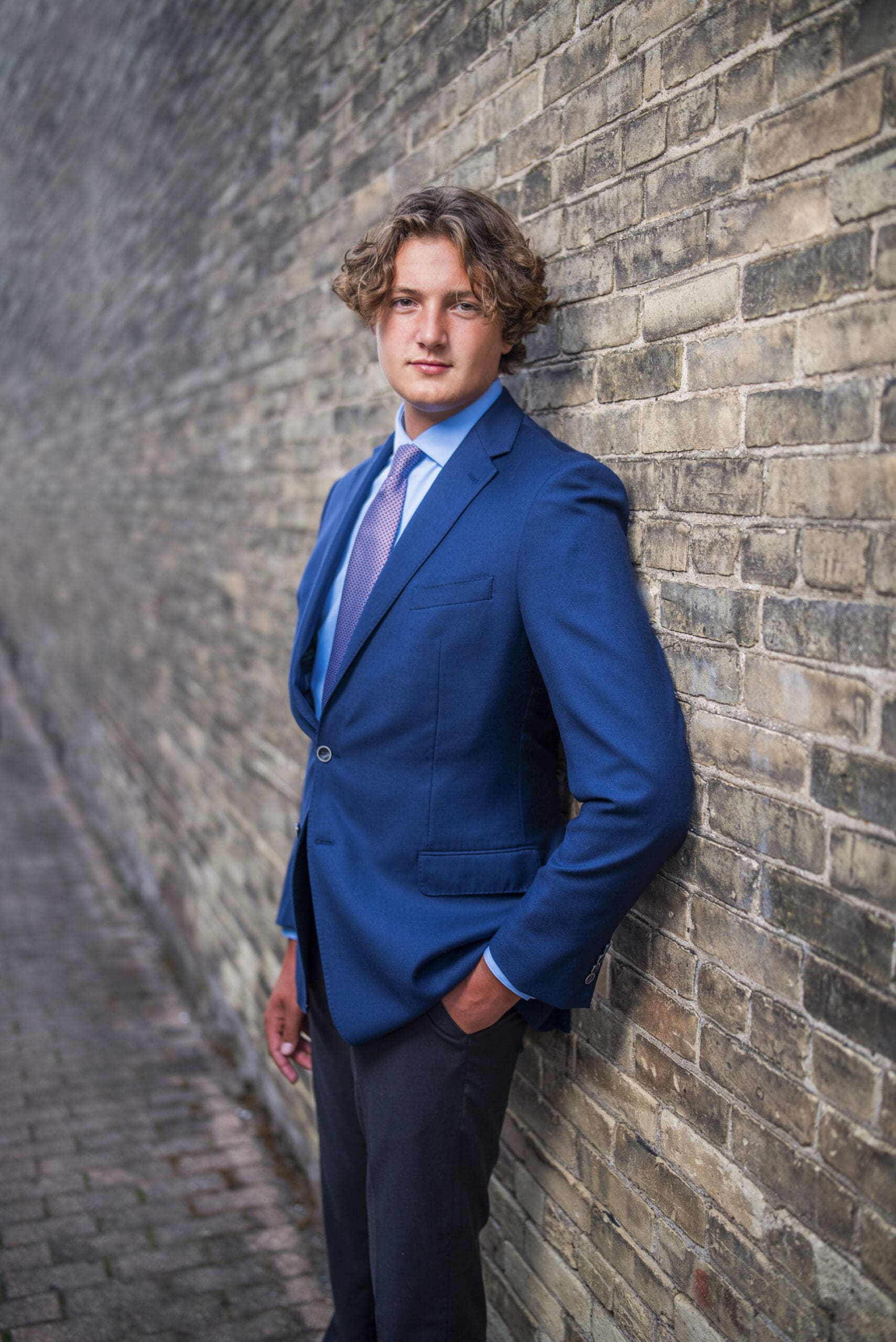 Senior leaning against wall downtown Oconomowoc. 