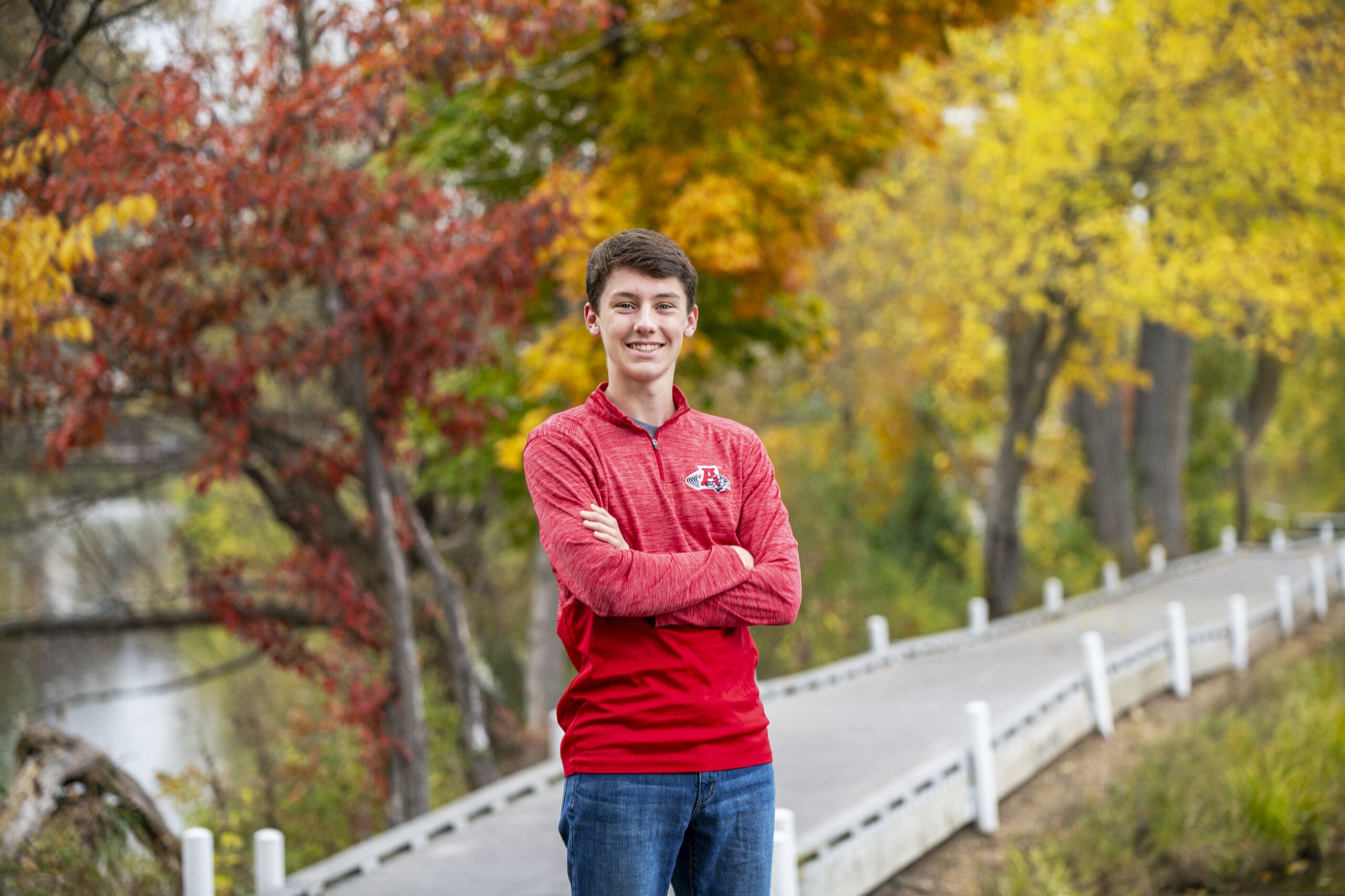 Oconomowoc senior crossing his arms on the path at the Fish Hatchery.