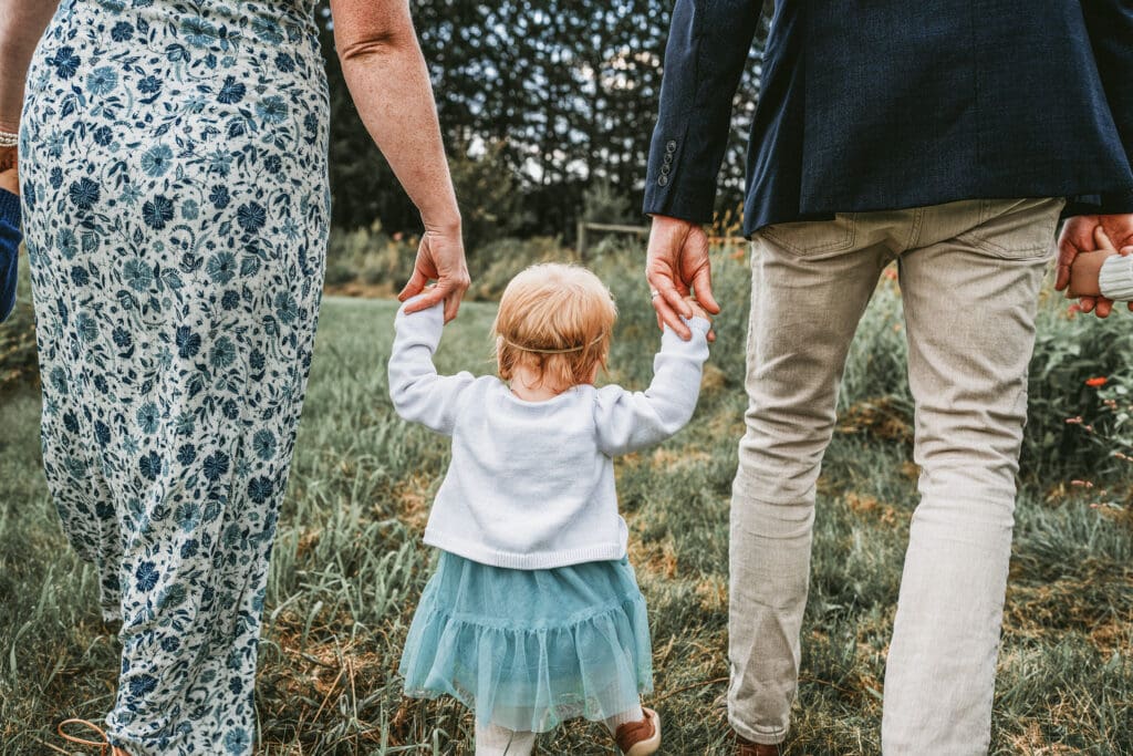 Family photography FAQ example showing candid family moments as parents walk with child. 