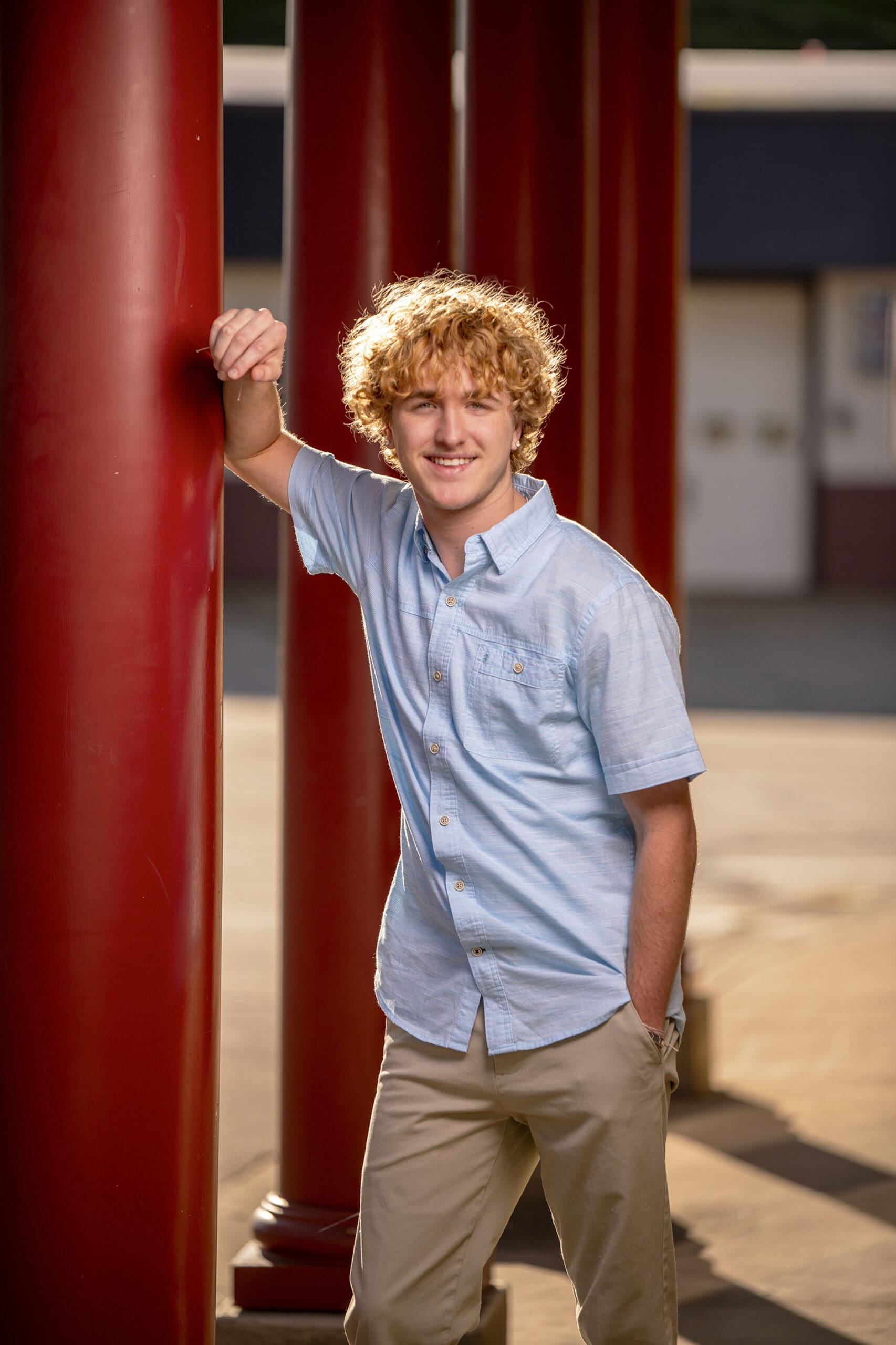 Pewaukee senior guy leaning agaist beam in downtown Oconomowoc. 