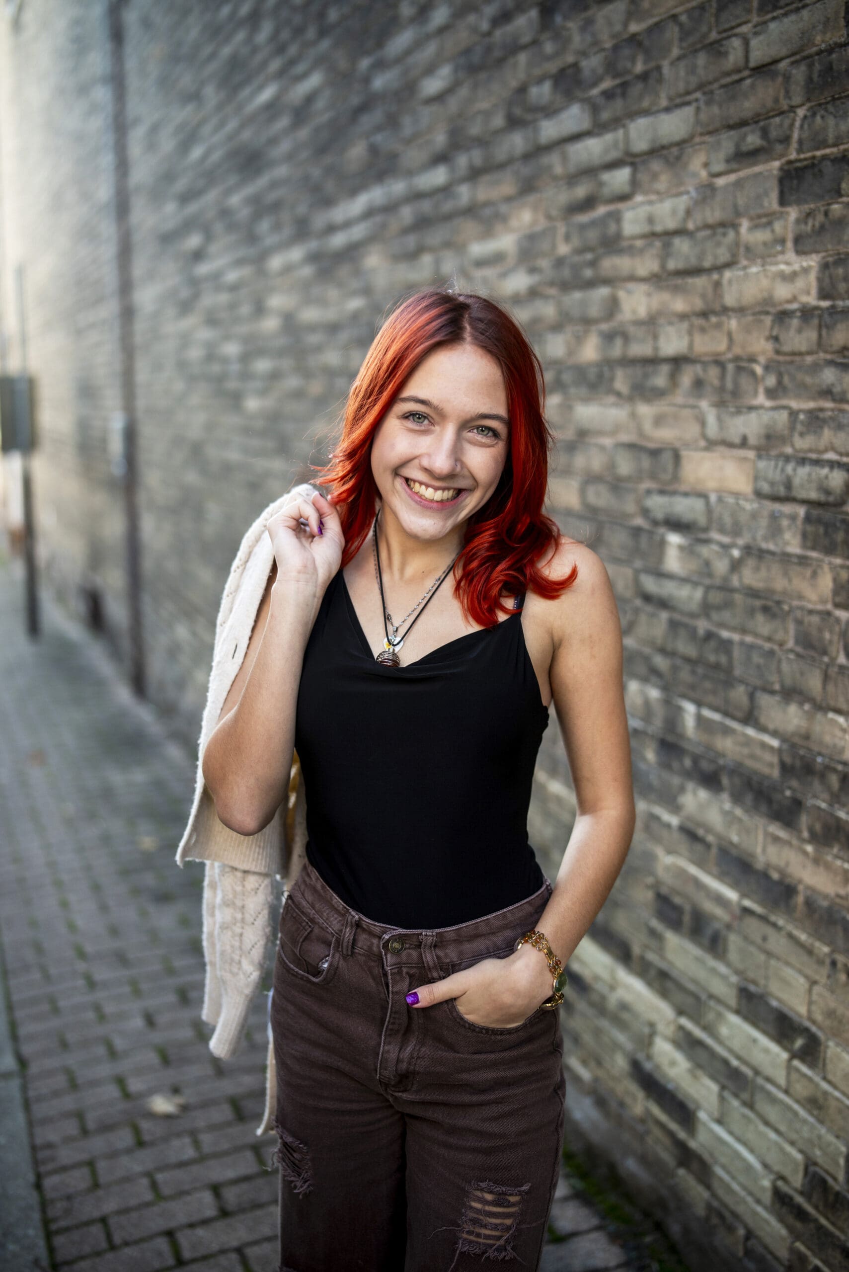 High school senior girl following senior girl photo tips during an outdoor portrait session.