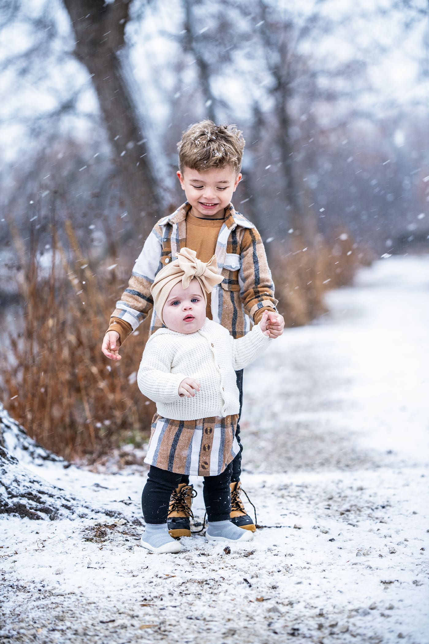 Siblings holding hands while it's snowing out in Delafield, WI. 