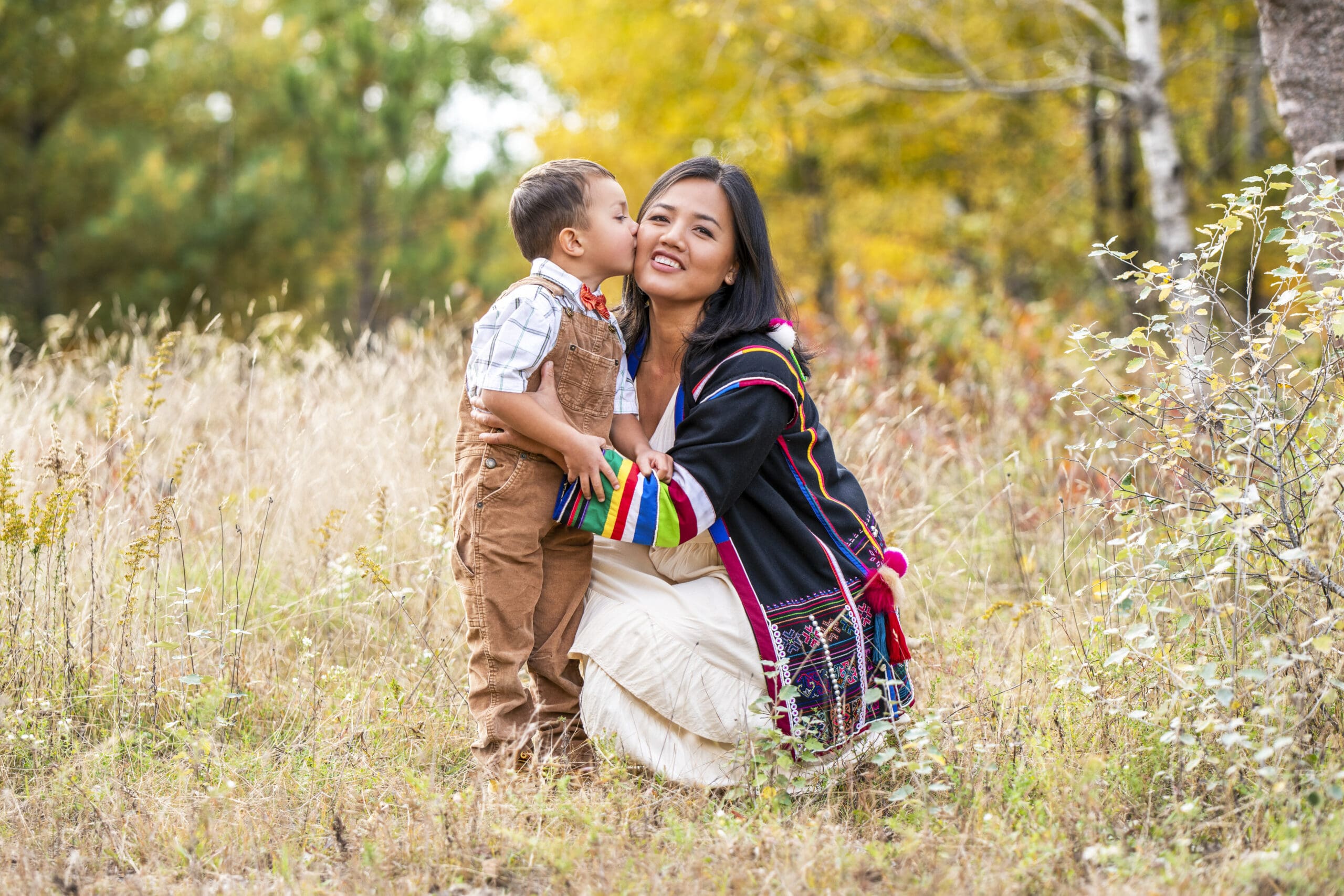 Waukesha mother crouching while her son kisses her during a Mini vs Full Sessions family photography example.