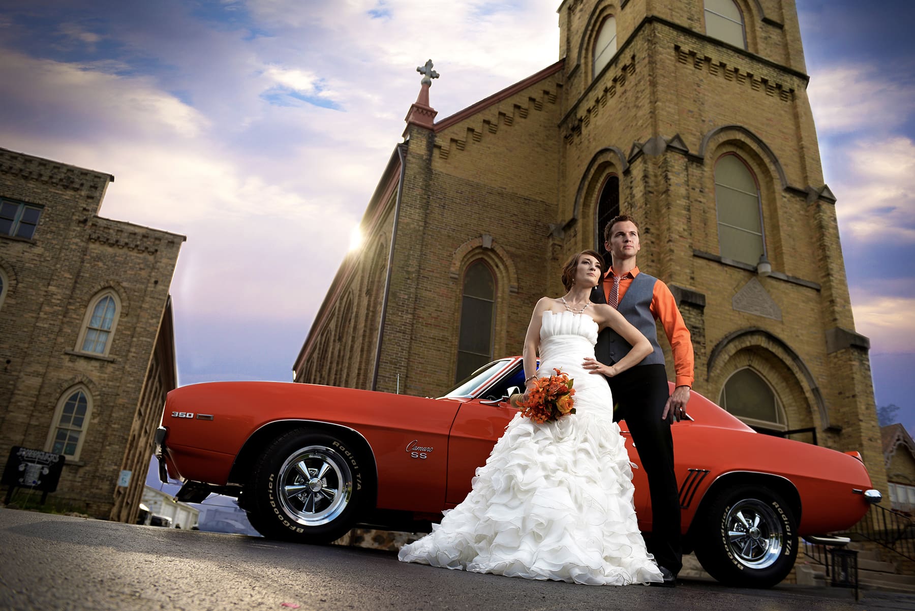 West Bend groom and bride posing with classic car