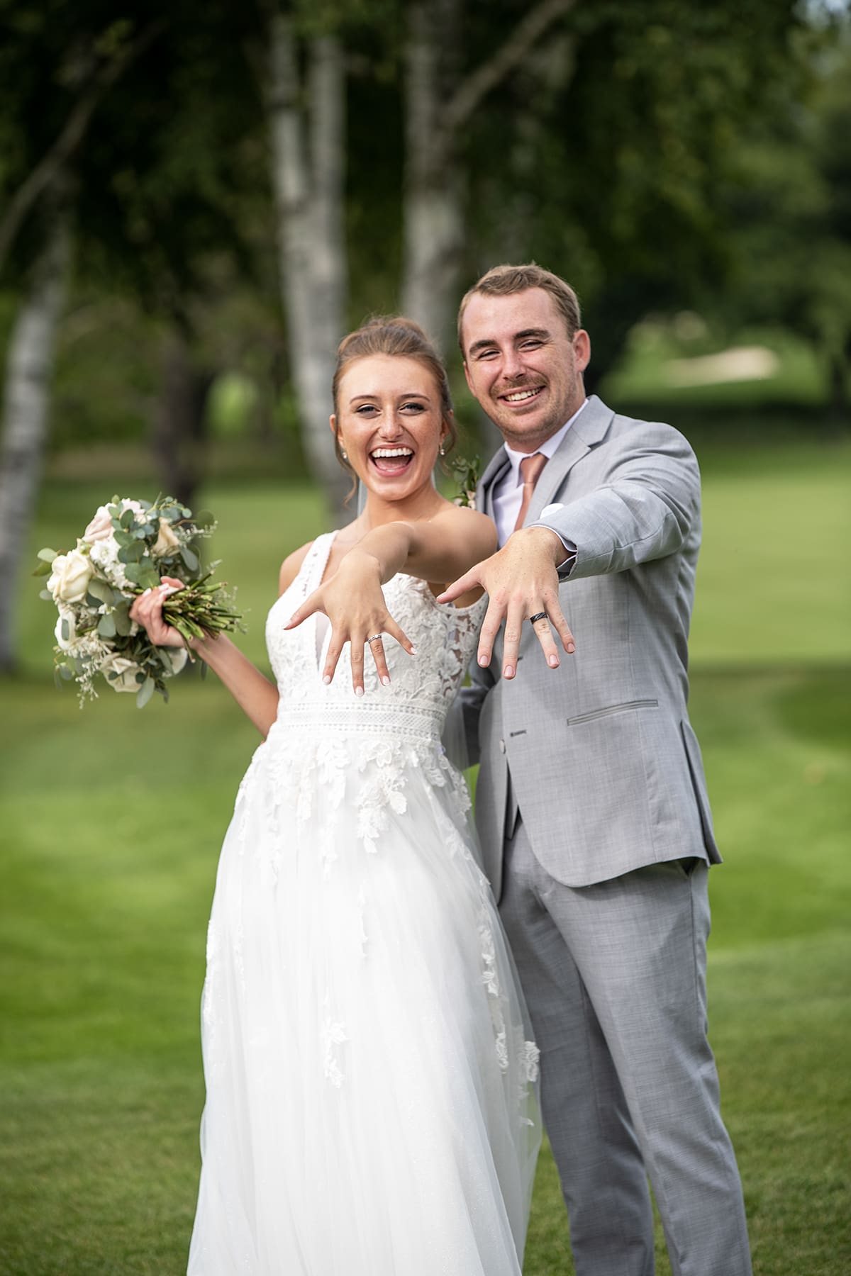 Groom and bride showing off their wedding rings as newly weds in Oconomowoc