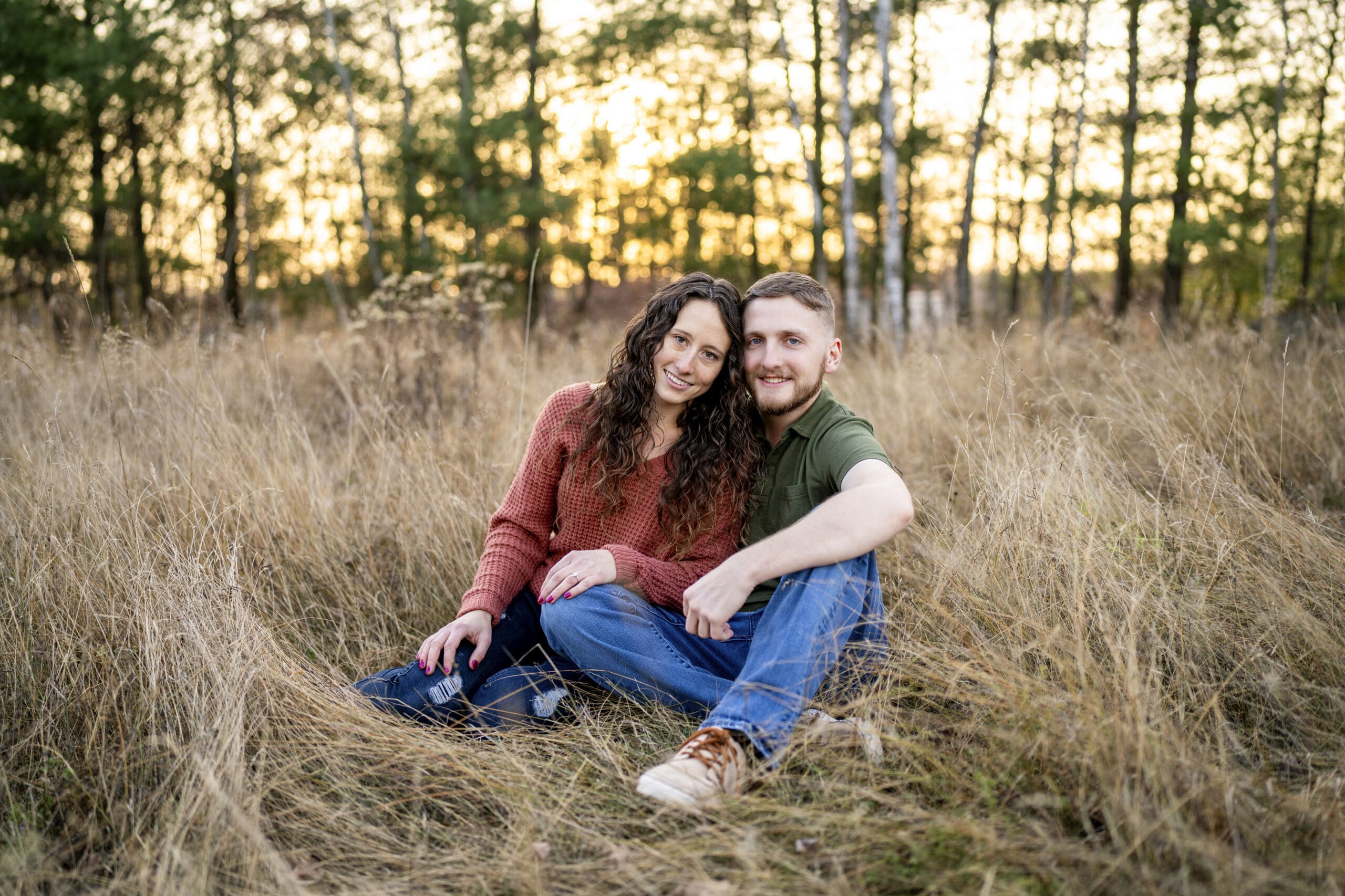 Wisconsin couple sitting in field during golden hour 