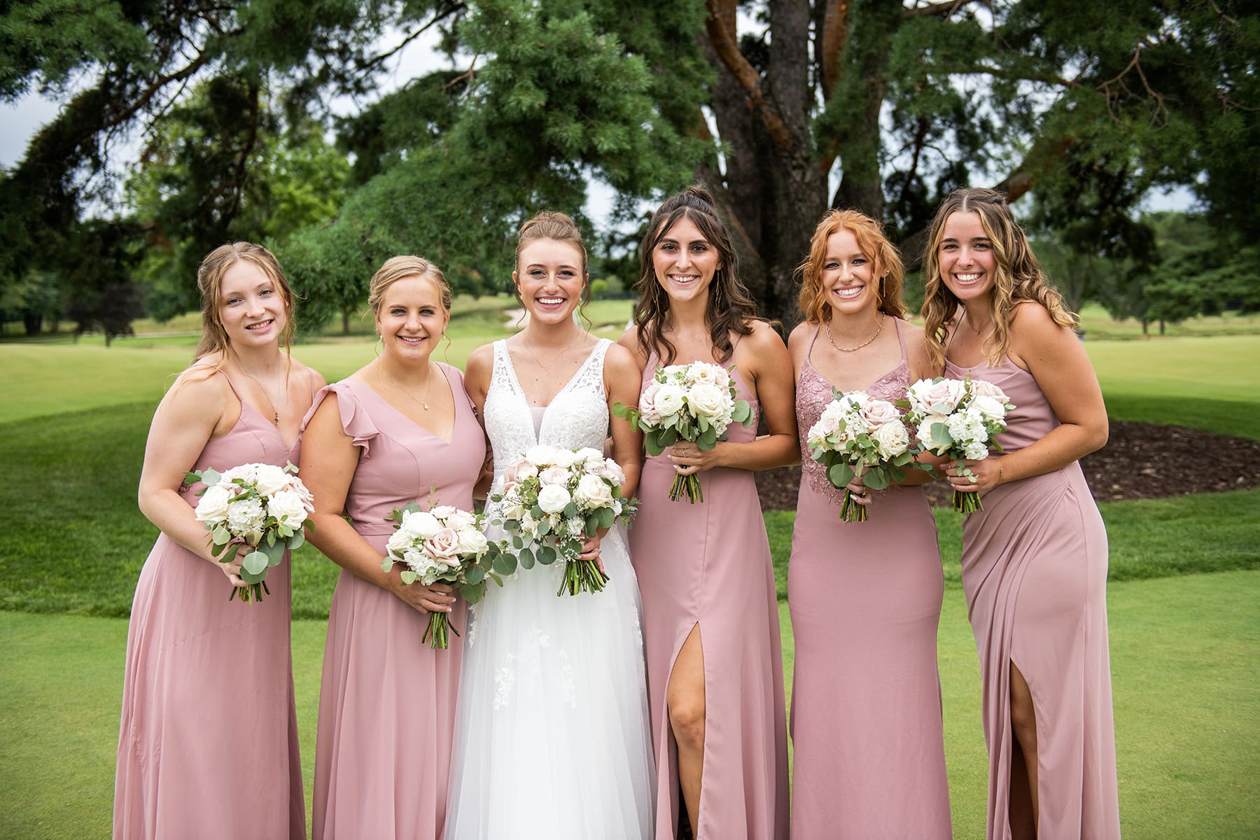 Bride and her bridesmaids posing for the camera in Oconomowoc