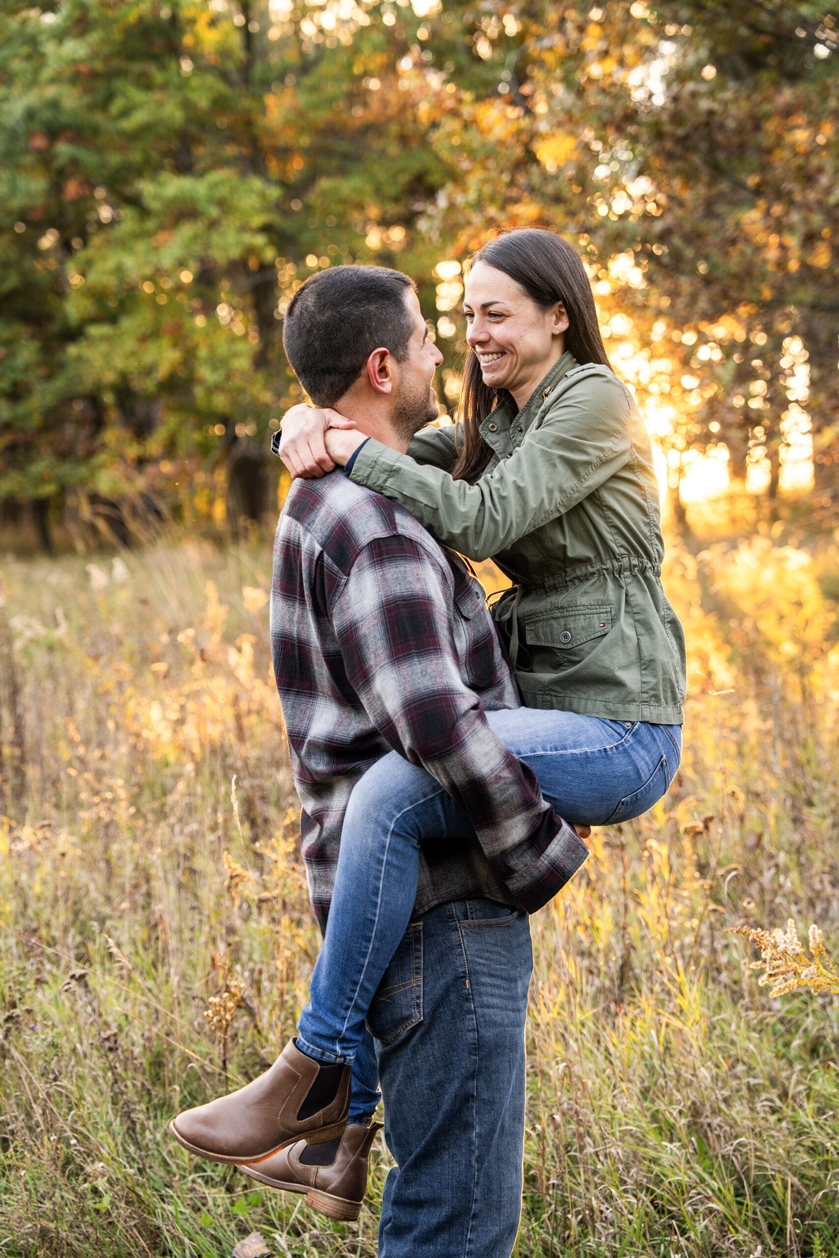 Engaged couple laughing during golden hour in Wisconsin field